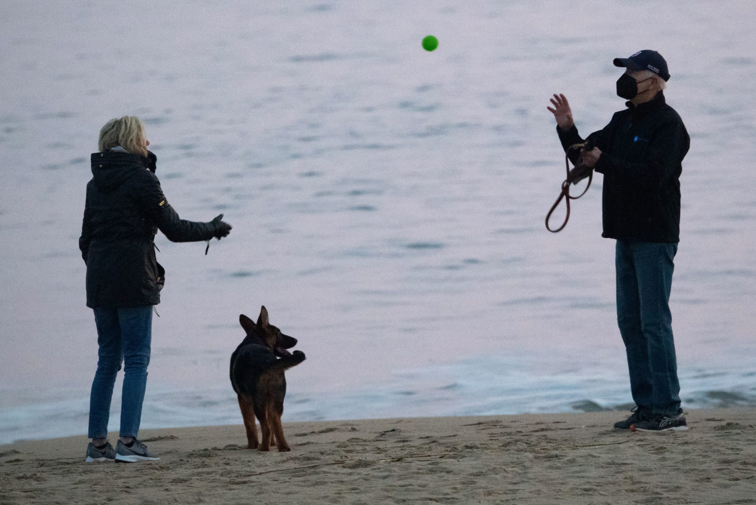 TOPSHOT - US President Joe Biden and US First Lady Jill Biden, play with their new dog Commander at Rehoboth Beach, Delaware, on December 28, 2021. (Photo by SAUL LOEB / AFP) (Photo by SAUL LOEB/AFP via Getty Images)