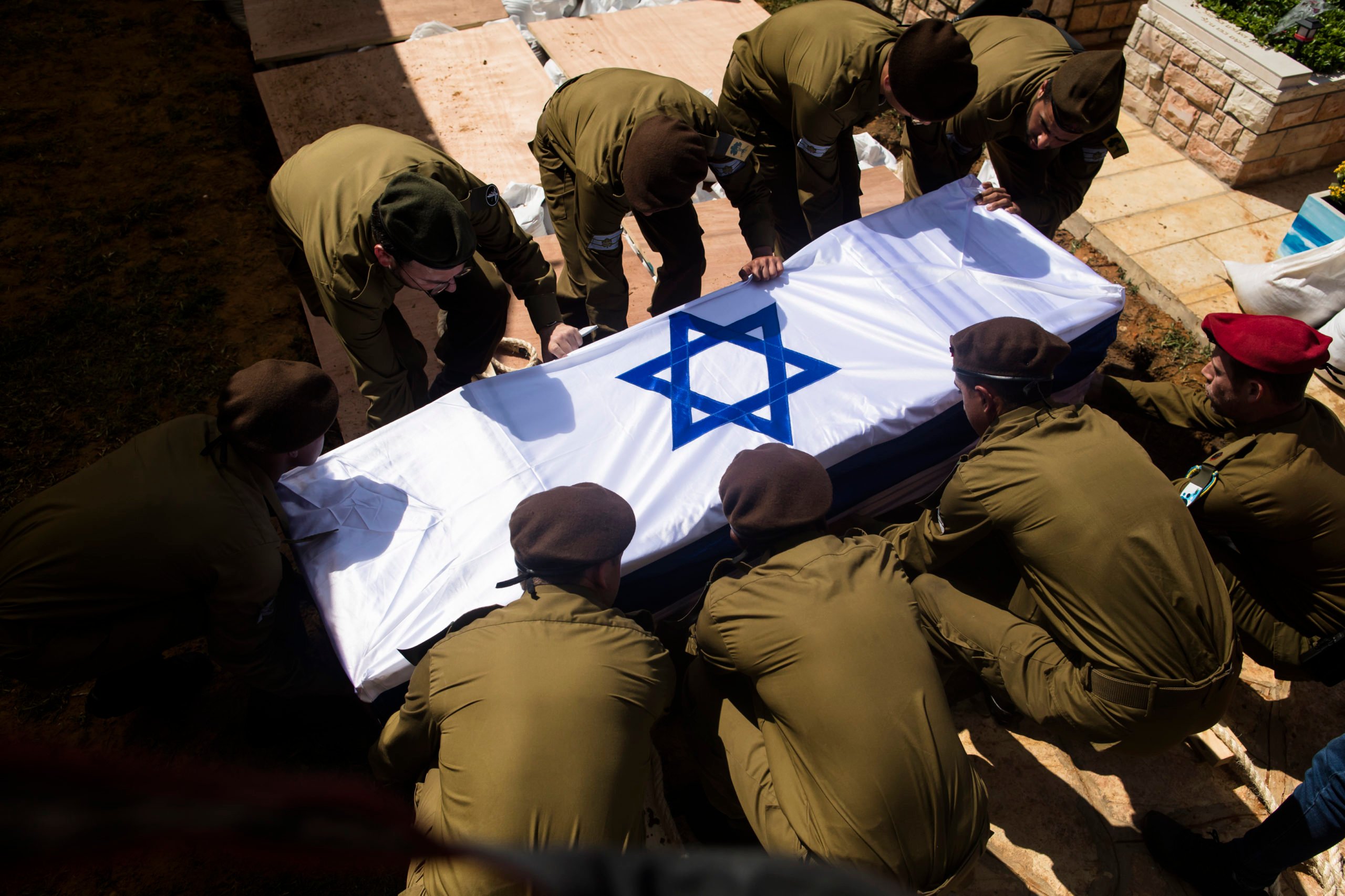 Soldiers carry the coffin of Dor Yarhi, who was killed in a battle with Palestinian militants near the Israeli border with the Gaza Strip during his funeral on October 12, 2023 in Rishon Lezion, Israel. Israel has sealed off Gaza and launched sustained retaliatory air strikes, which have killed at least 1,200 people with more than 300, 000 displaced, after a large-scale attack by Hamas. On October 7, the Palestinian militant group Hamas launched a surprise attack on Israel from Gaza by land, sea, and air, killing over 1,200 people and wounding around 2800. Israeli soldiers and civilians have also been taken hostage by Hamas and moved into Gaza. The attack prompted a declaration of war by Israeli Prime Minister Benjamin Netanyahu. (Photo by Amir Levy/Getty Images)