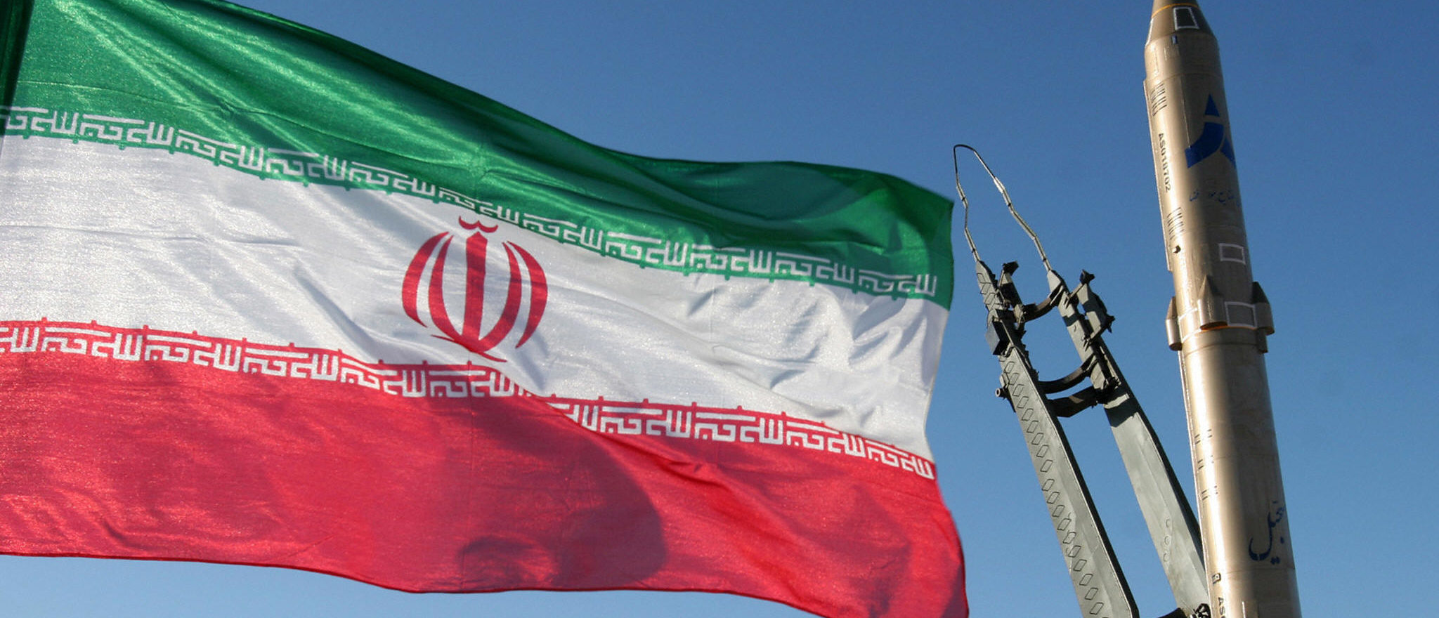 An Iranian flag flutters next to a ground-to-ground Sajil missile before being launched at an undisclosed location in Iran on November 12, 2008. Iran test fired today a new generation of ground-to-ground missile, the semi-official Fars news agency quoted the defence minister as saying. In the past Iran has often boasted of developing new weapons systems only to be met with scepticism from Western defence analysts. AFP PHOTO/FARS NEWS/STR (Photo credit should read -/AFP via Getty Images)