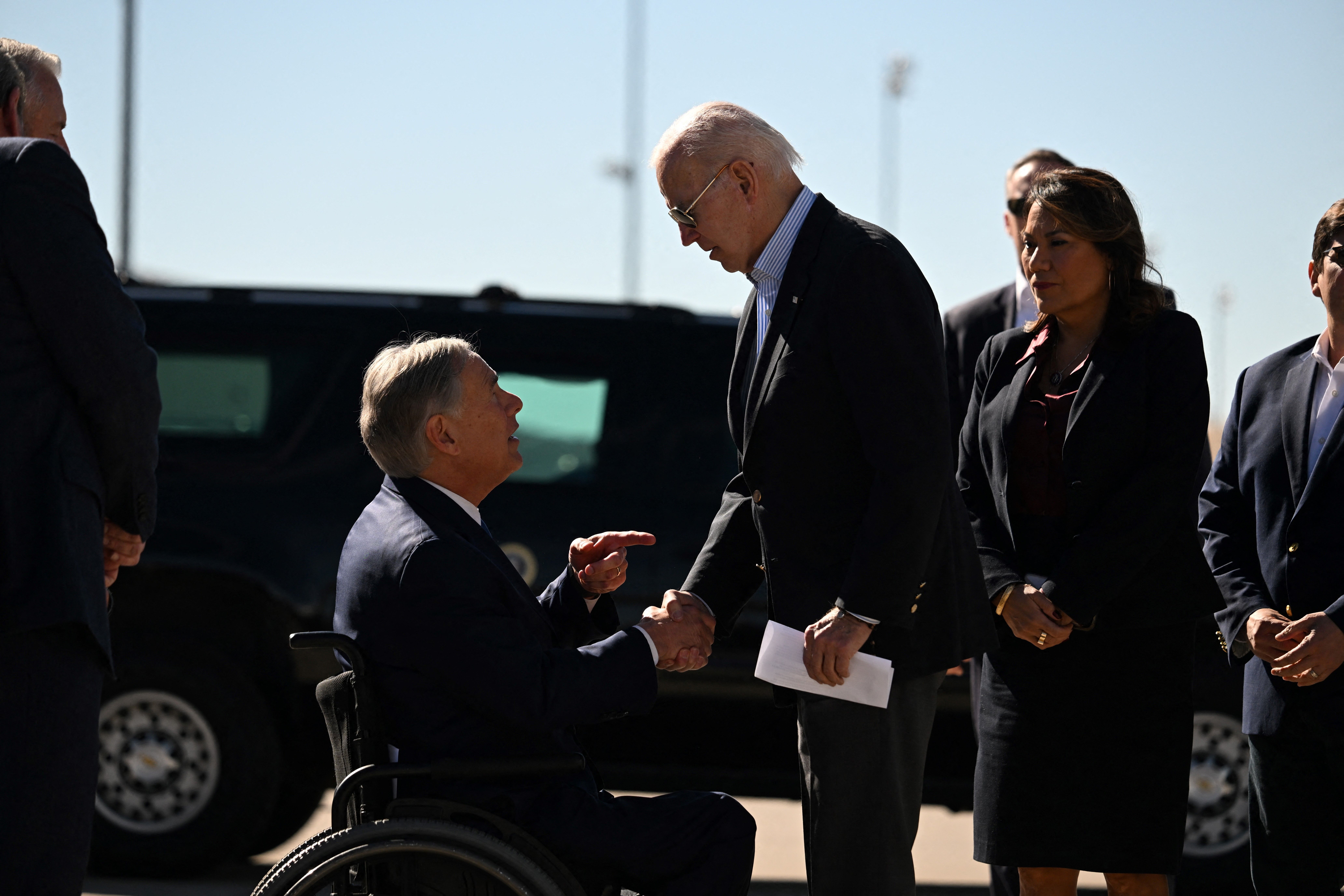 US President Joe Biden shakes hands with Texas Governor Greg Abbott after Abbott handed him a letter outlining the problems on the southern border upon arrival at El Paso International Airport in El Paso, Texas, on January 8, 2023. (Photo by Jim WATSON / AFP) (Photo by JIM WATSON/AFP via Getty Images)
