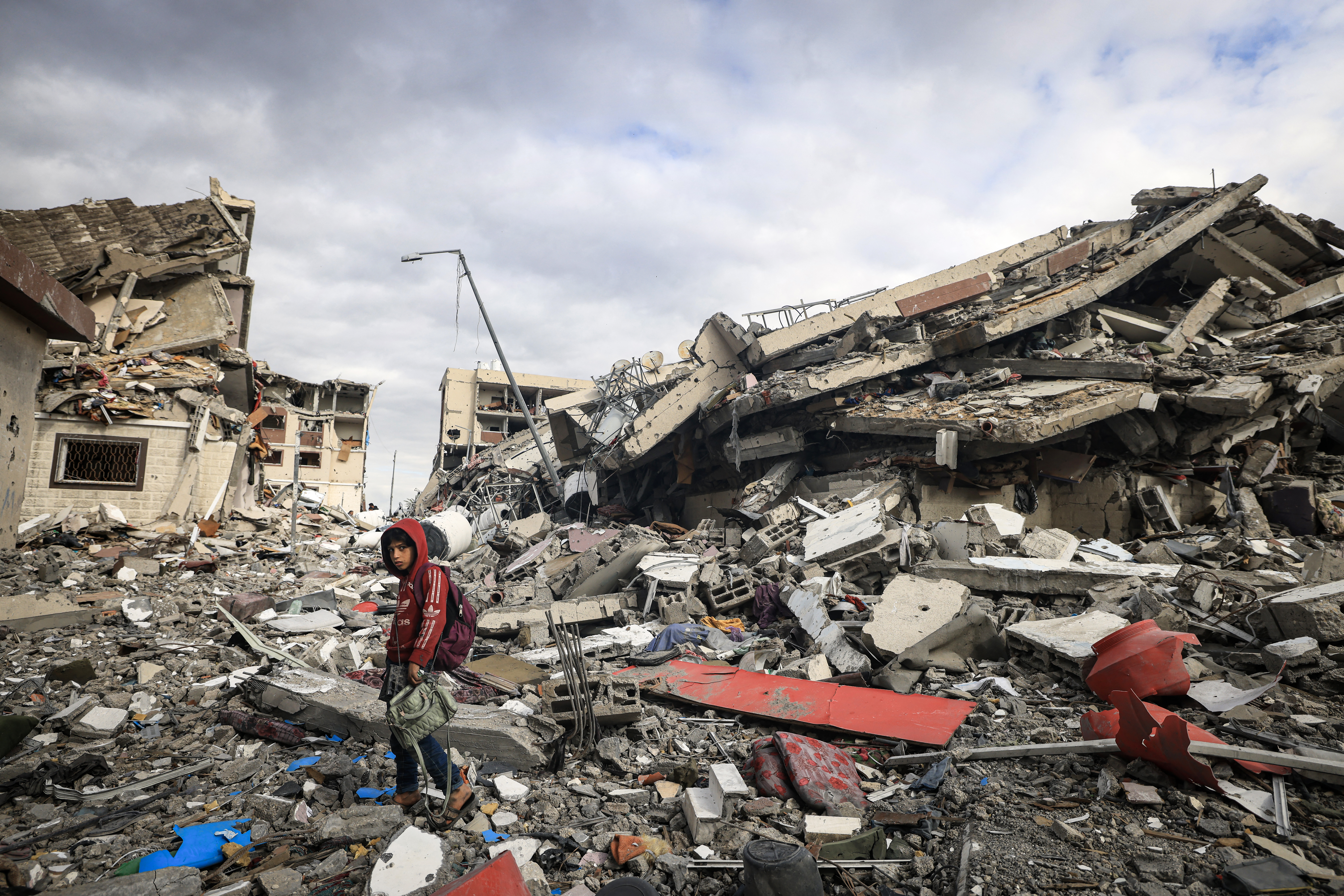 Palestinians inspect the destruction caused by Israeli strikes in Wadi Gaza, in the central Gaza Strip on November 28, 2023, amid a truce in battles between Israel and Hamas. (Photo by MAHMUD HAMS/AFP via Getty Images)