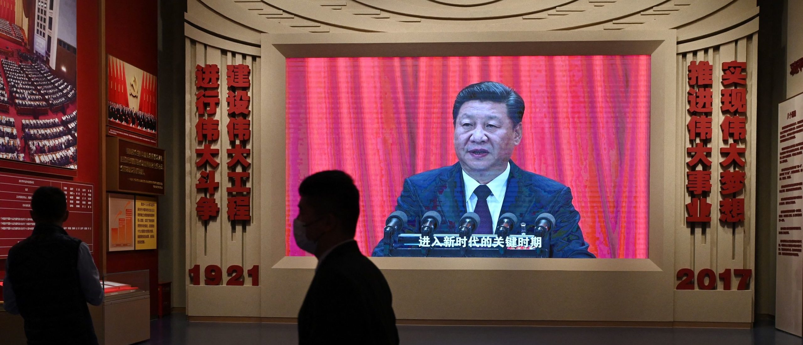 A man walks past a video screen showing a speech by Chinese President Xi Jinping at the Museum of the Communist Party of China in Beijing on March 3, 2023, ahead of the opening of the annual session of the National Peoples Congress on March 5. (Photo by GREG BAKER / AFP) 