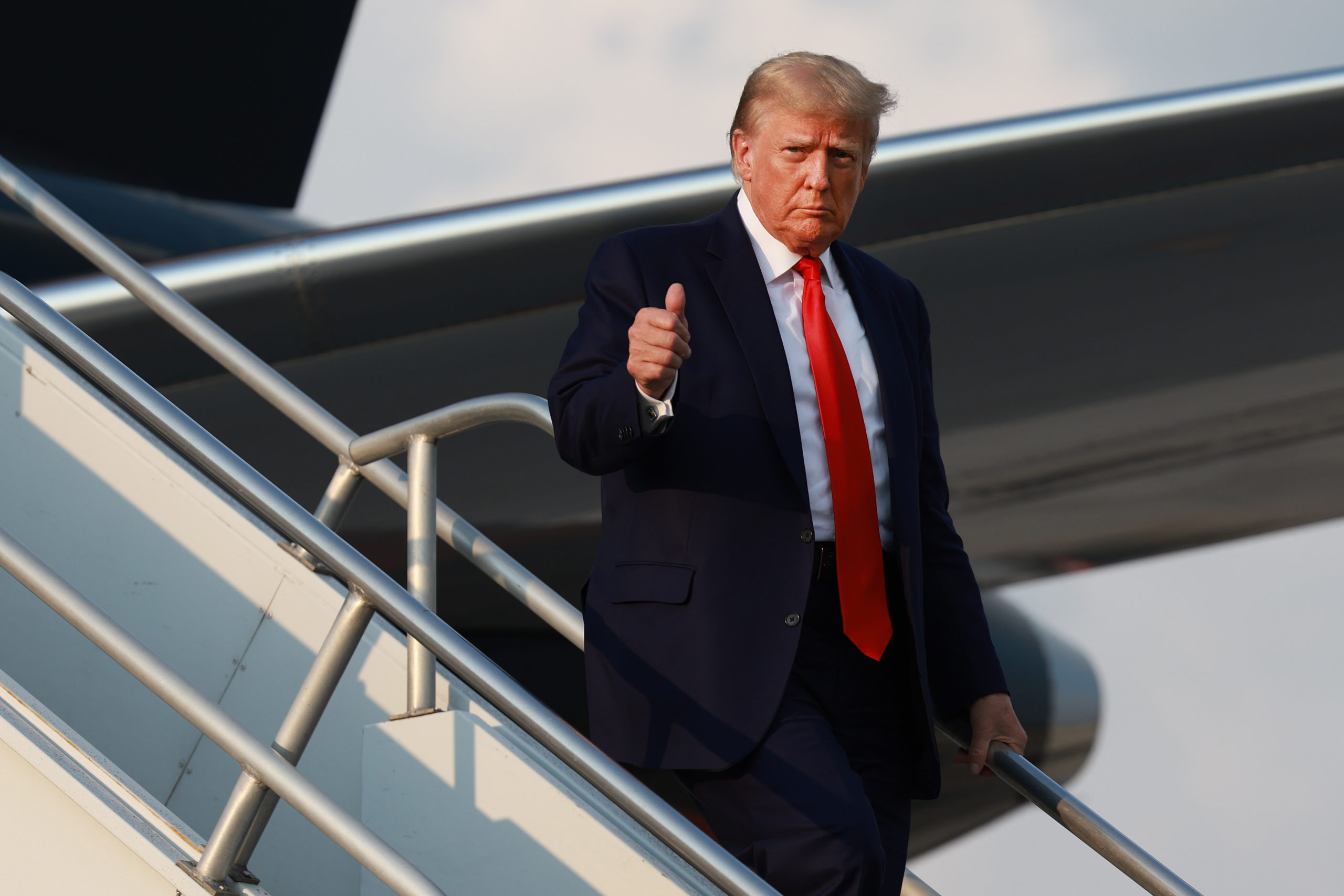ATLANTA, GEORGIA - AUGUST 24: Former U.S. President Donald Trump gives a thumbs up as he arrives at Atlanta Hartsfield-Jackson International Airport on August 24, 2023 in Atlanta, Georgia. Trump is expected to surrender at the Fulton County jail, where he will be booked on 13 charges related to an alleged plan to overturn the results of the 2020 presidential election in Georgia. (Photo by Joe Raedle/Getty Images)