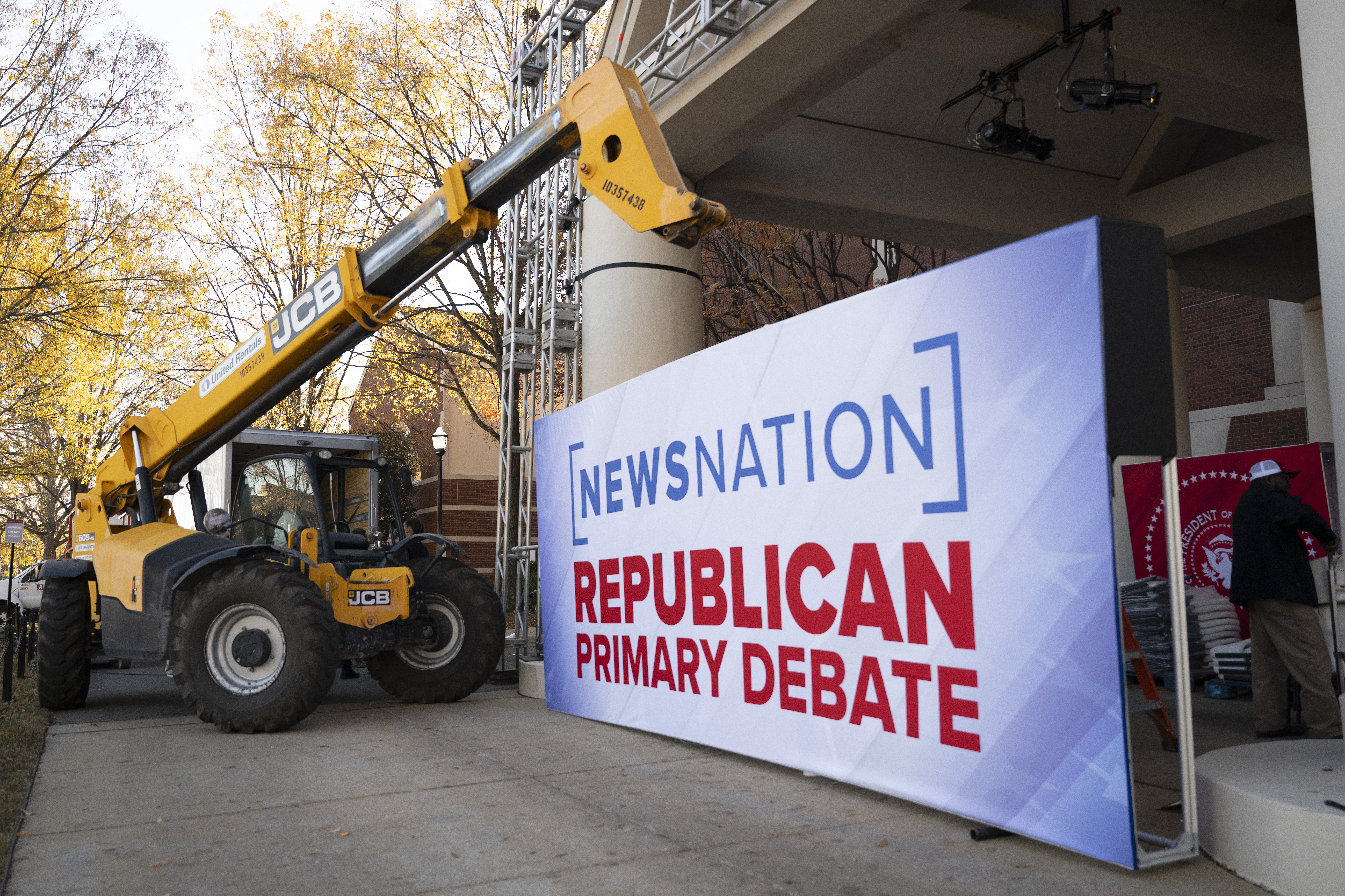 Workers prepare to install a sign outside of the Frank Moody Music Building at the University of Alabama in Tuscaloosa, Alabama, on December 05, 2023, ahead of the fourth Republican Presidential debate. (Photo by Jim WATSON / AFP) (Photo by JIM WATSON/AFP via Getty Images)