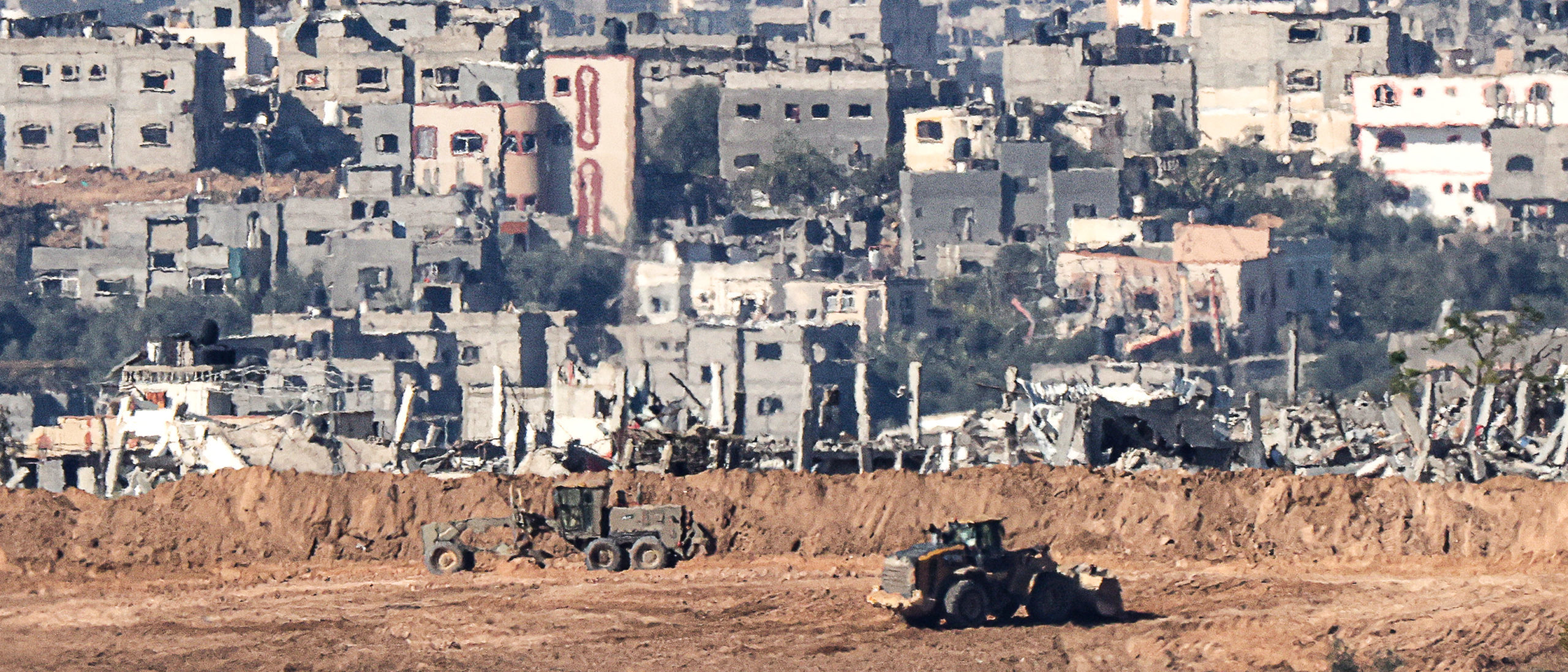 A picture taken in southern Israel near the border with the Gaza Strip on December 15, 2023, shows Israeli military bulldozers working in northern Gaza, amid continuing battles between Israel and the Palestinian militant group Hamas. (Photo by JACK GUEZ / AFP) (Photo by JACK GUEZ/AFP via Getty Images)