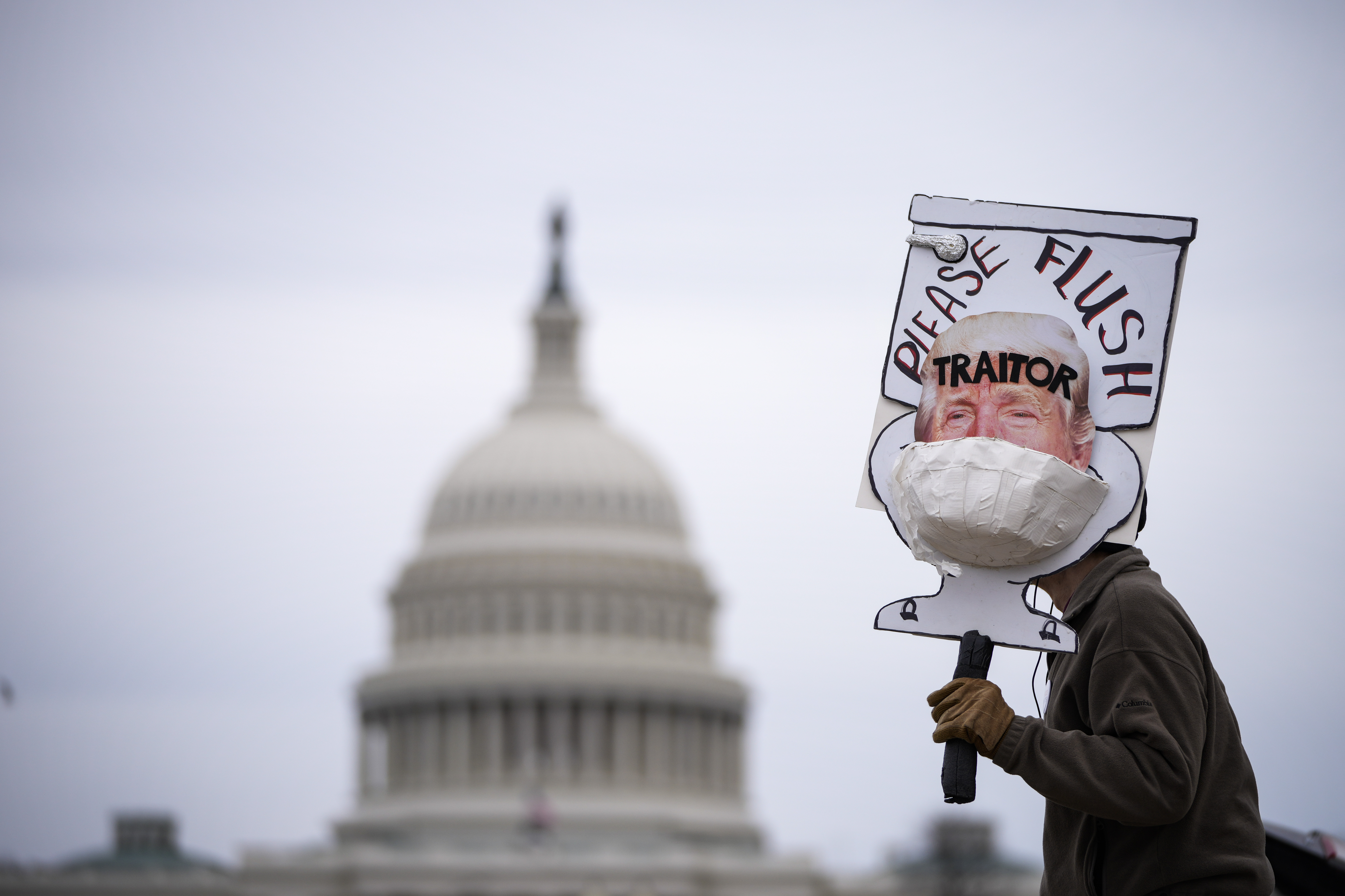 Bill Wood demonstrates with an anti-Trump sign near the U.S. Capitol on January 06, 2022 in Washington, DC. One year ago, supporters of President Donald Trump attacked the U.S. Capitol Building in an attempt to disrupt a congressional vote to confirm the electoral college win for Joe Biden. (Photo by Drew Angerer/Getty Images)
