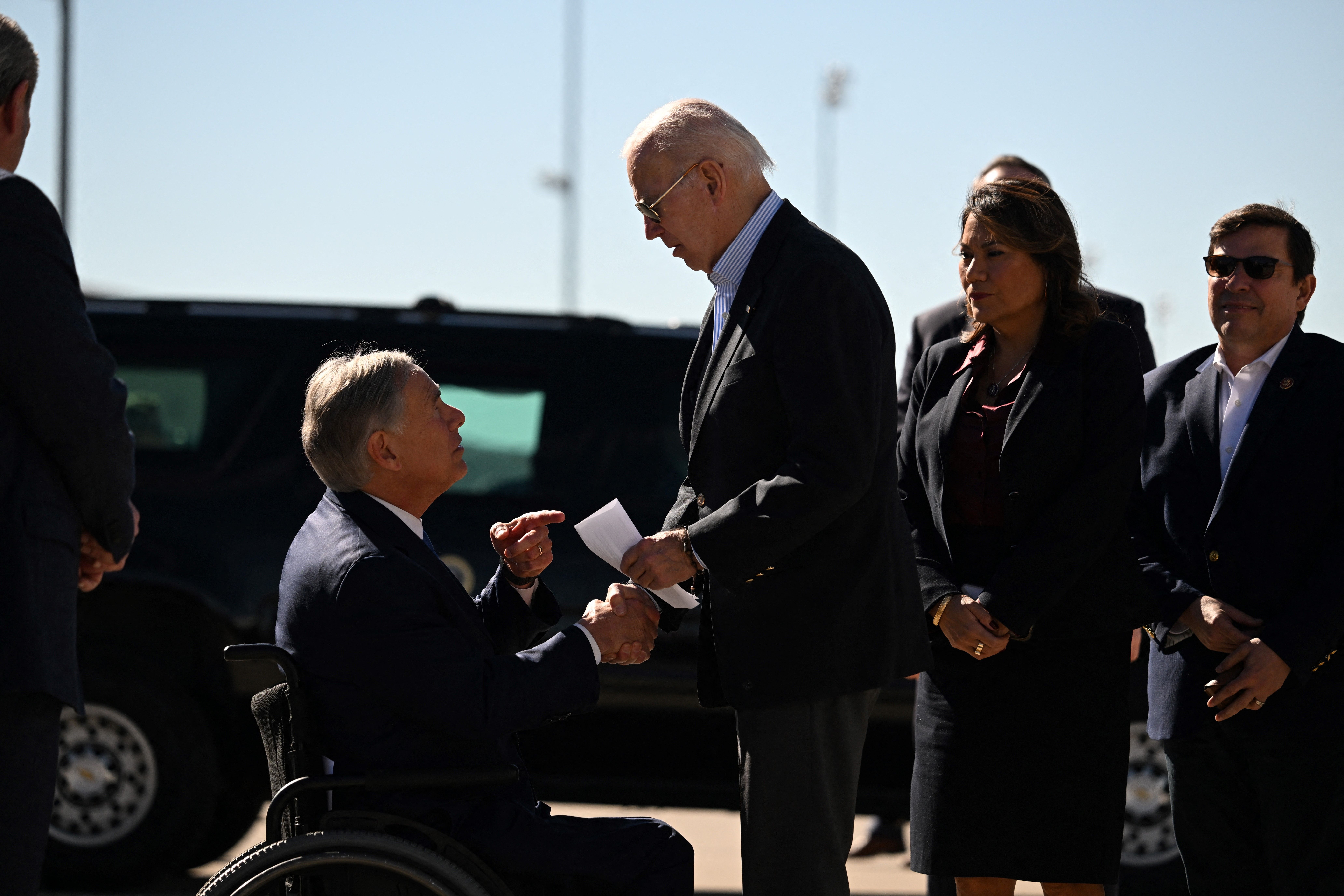US President Joe Biden shakes hands with Texas Governor Greg Abbott after Abbott handed him a letter outlining the problems on the southern border upon arrival at El Paso International Airport in El Paso, Texas, on January 8, 2023. (Photo by Jim WATSON / AFP) (Photo by JIM WATSON/AFP via Getty Images)