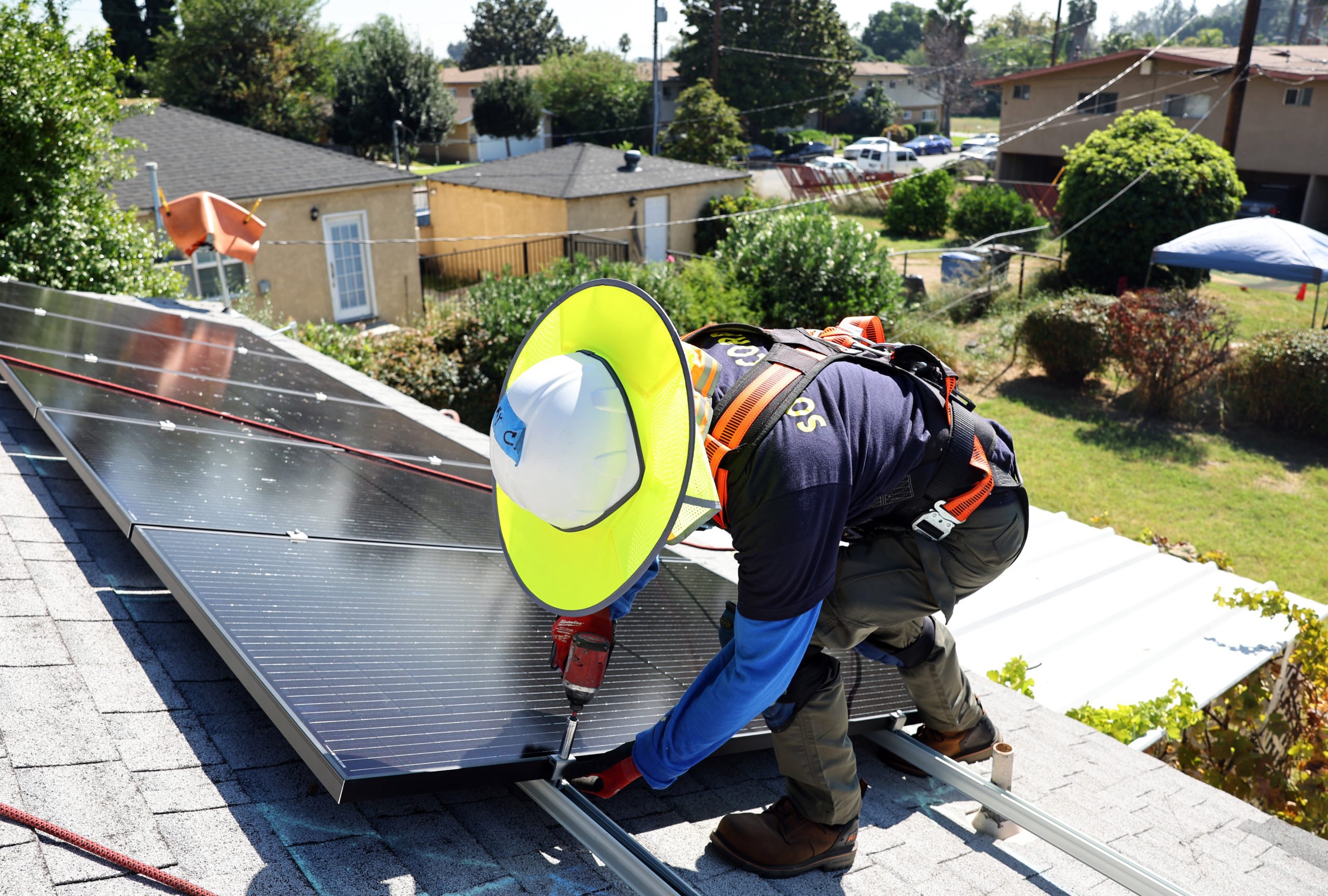 An employee for GRID Alternatives installs no-cost solar panels on the rooftop of a low-income household on October 19, 2023 in Pomona, California. (Photo by Mario Tama/Getty Images)