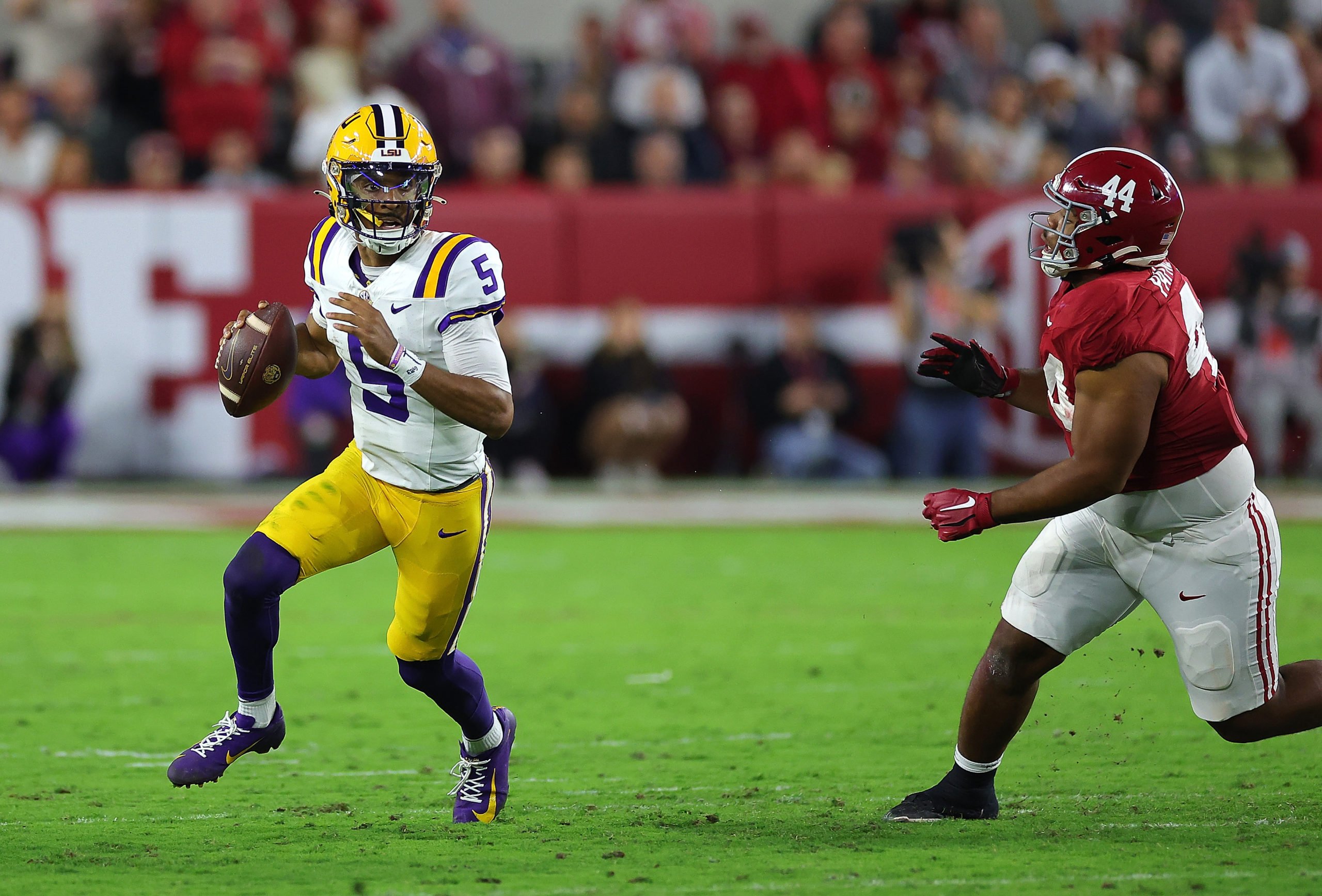 TUSCALOOSA, ALABAMA - NOVEMBER 04: Jayden Daniels #5 of the LSU Tigers rushes out of the pocket away from Damon Payne Jr. #44 of the Alabama Crimson Tide during the second quarter at Bryant-Denny Stadium on November 04, 2023 in Tuscaloosa, Alabama. Kevin C. Cox/Getty Images