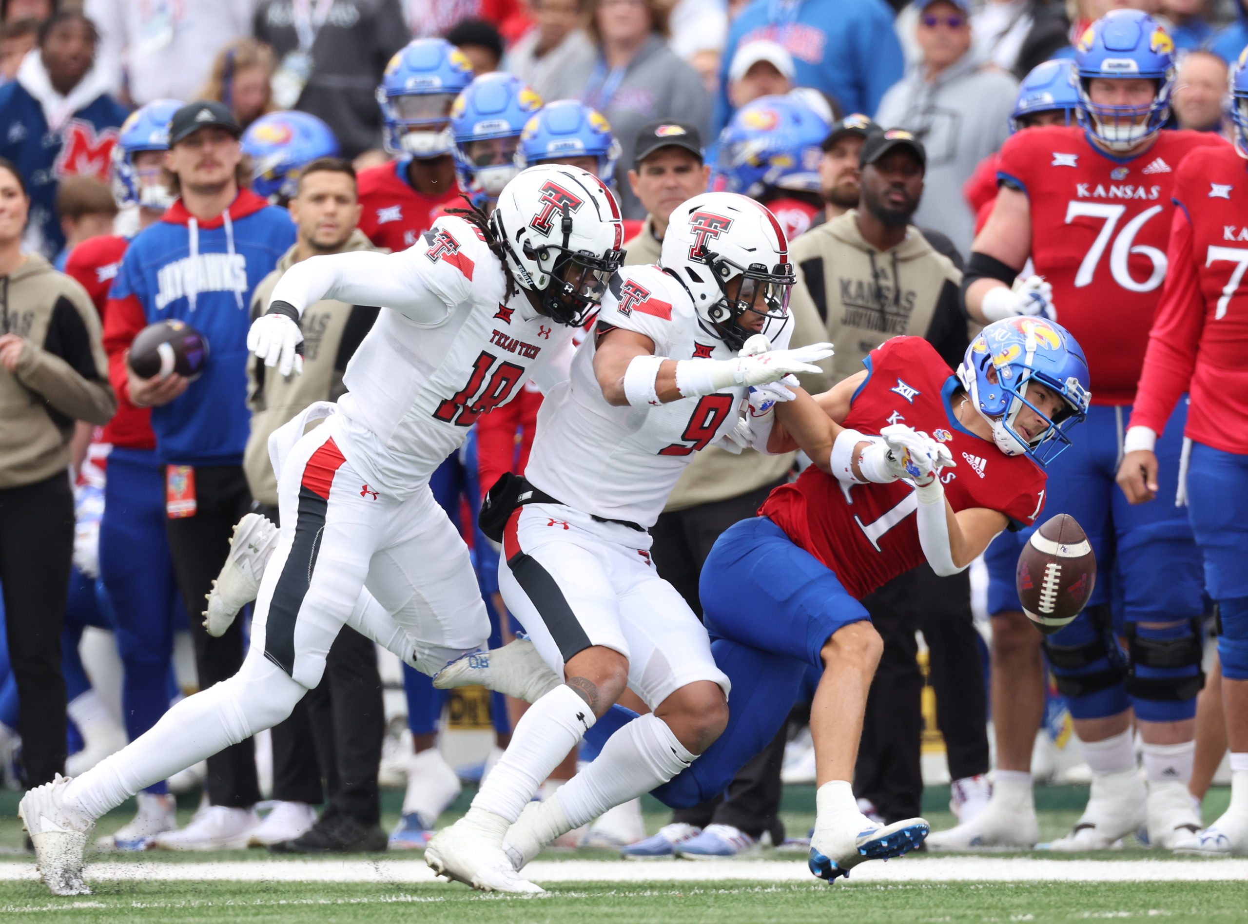 LAWRENCE, KANSAS - NOVEMBER 11: Defensive back Tyler Owens #18 and defensive back C.J. Baskerville #9 of the Texas Tech Red Raiders break up a pass intended for wide receiver Luke Grimm #11 of the Kansas Jayhawks during the game at David Booth Kansas Memorial Stadium on November 11, 2023 in Lawrence, Kansas. Jamie Squire/Getty Images