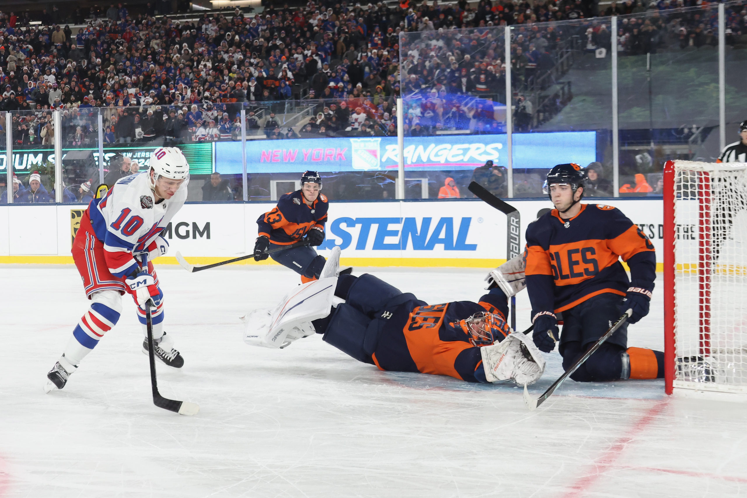 EAST RUTHERFORD, NEW JERSEY - FEBRUARY 18: Artemi Panarin #10 of the New York Rangers score sthe game-winning goal in overtime against the New York Islanders during the 2004 Navy Federal Credit Union Stadium Series game at MetLife Stadium on February 18, 2024 in East Rutherford, New Jersey. Bruce Bennett/Getty Images