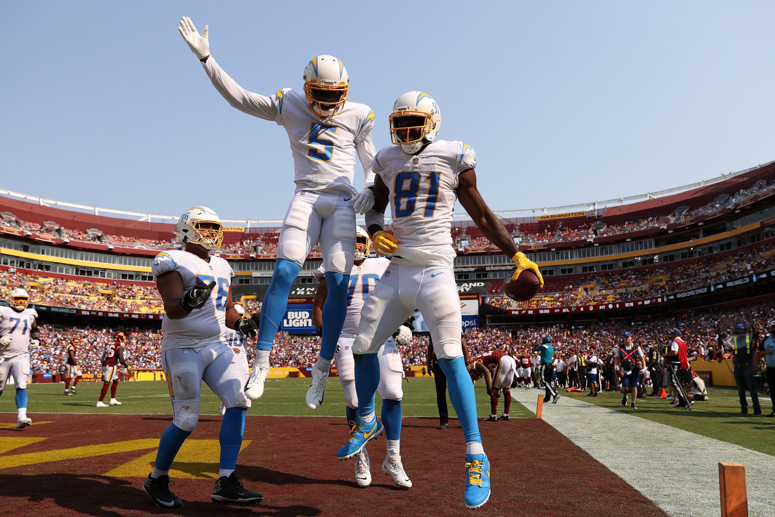 LANDOVER, MARYLAND - SEPTEMBER 12: Mike Williams #81 of the Los Angeles Chargers celebrates with teammates after catching a three yard touchdown reception during the fourth quarter against the Washington Football Team at FedExField on September 12, 2021 in Landover, Maryland. Patrick Smith/Getty Images