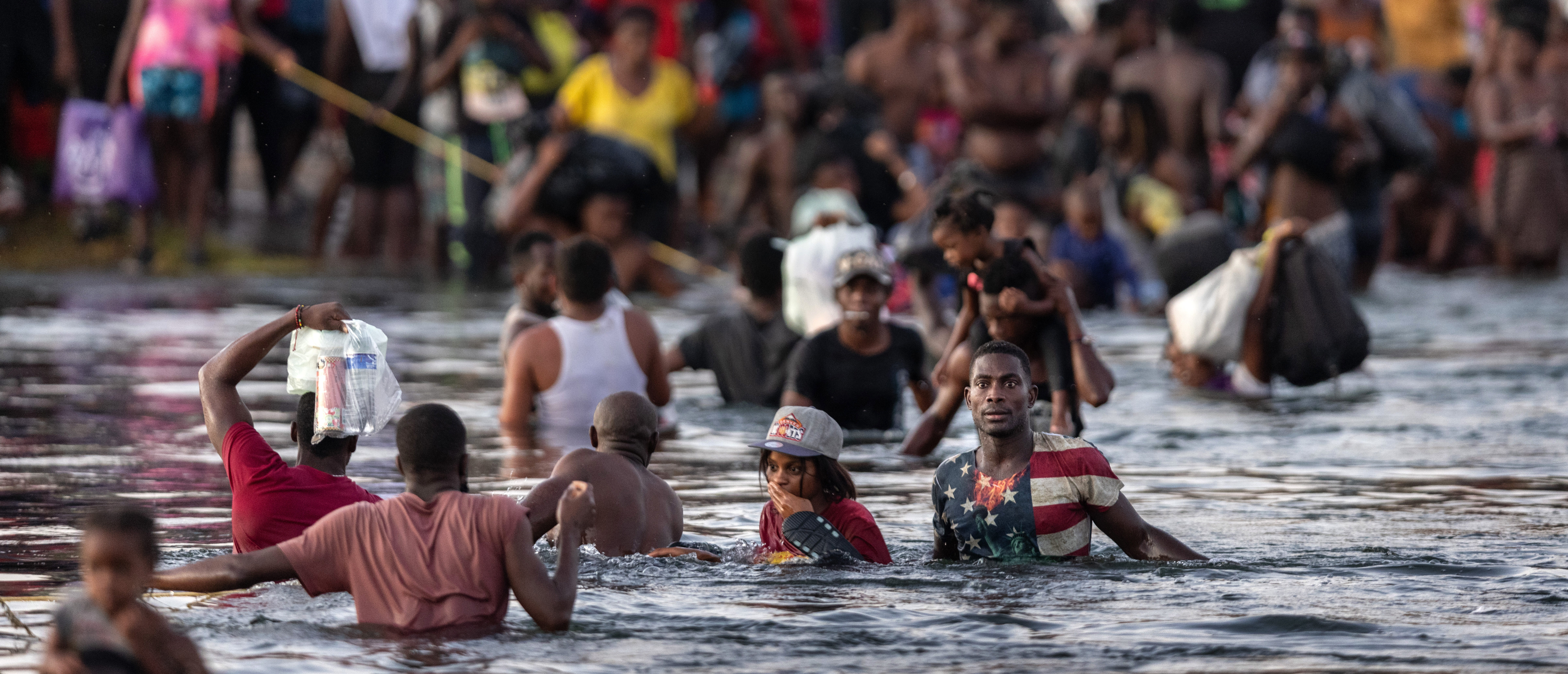 CIUDAD ACUNA, TEXAS - SEPTEMBER 19: Immigrants, mostly from Haiti gather on the bank of the Rio Grande on September 19, 2021 in Ciudad Acuna, Mexico, across the border from Del Rio, Texas. As U.S. immigration authorities began deporting immigrants back to Haiti from Del Rio, thousands more waited in a camp under an international bridge in Del Rio and others crossed the river back into Mexico. (Photo by John Moore/Getty Images)