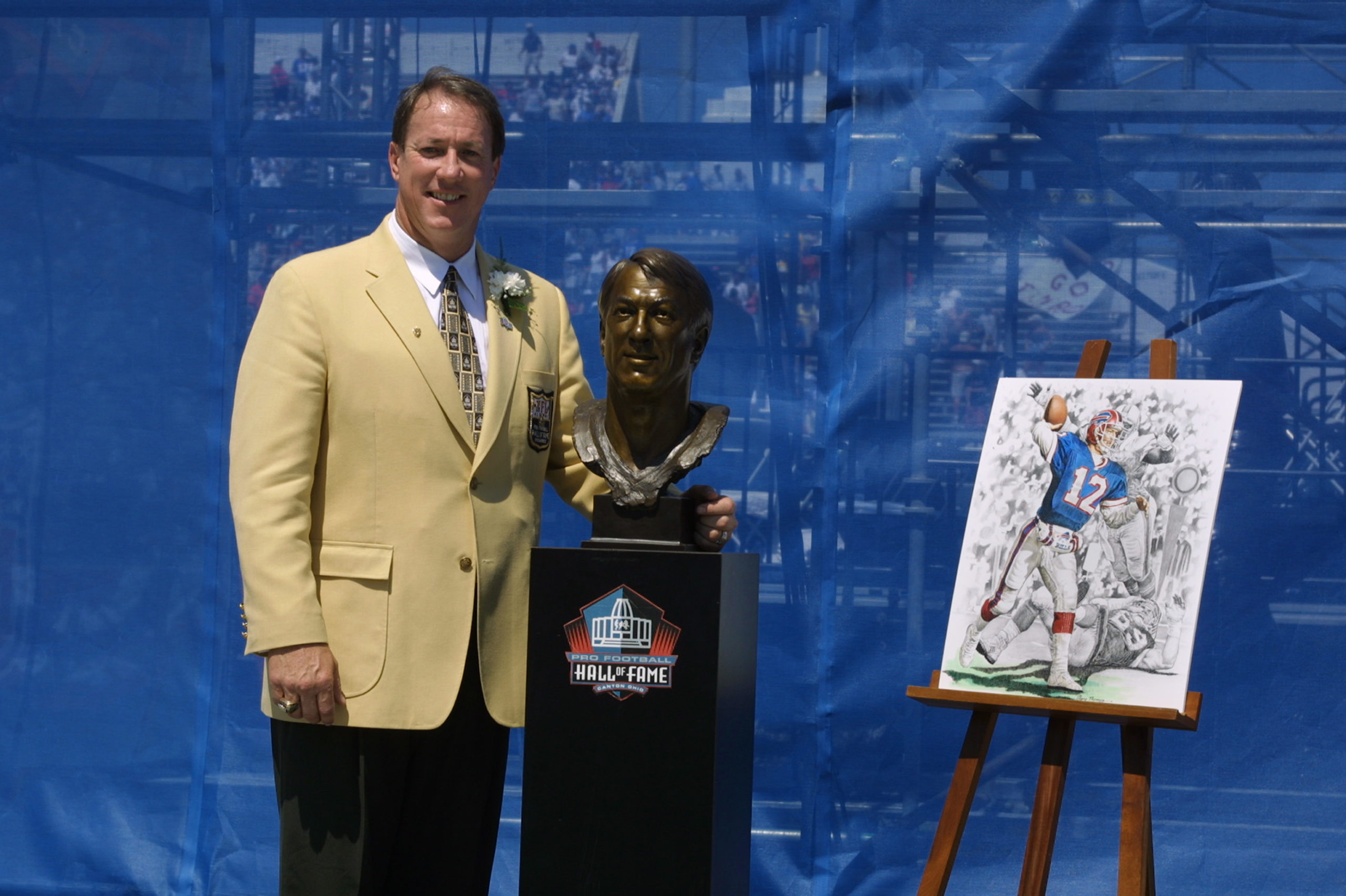 CANTON, OHIO - AUGUST 3: Jim Kelly stands next to his bust and artwork after his induction into the National Football League Hall of Fame on August 3, 2002 at Fawcett Stadium in Canton, Ohio. Kelly played quarterback for the Buffalo Bills from 1986 to 1996 and led the Bills to four straight Super Bowl appearences during his NFL career. Rick Stewart/Getty Images