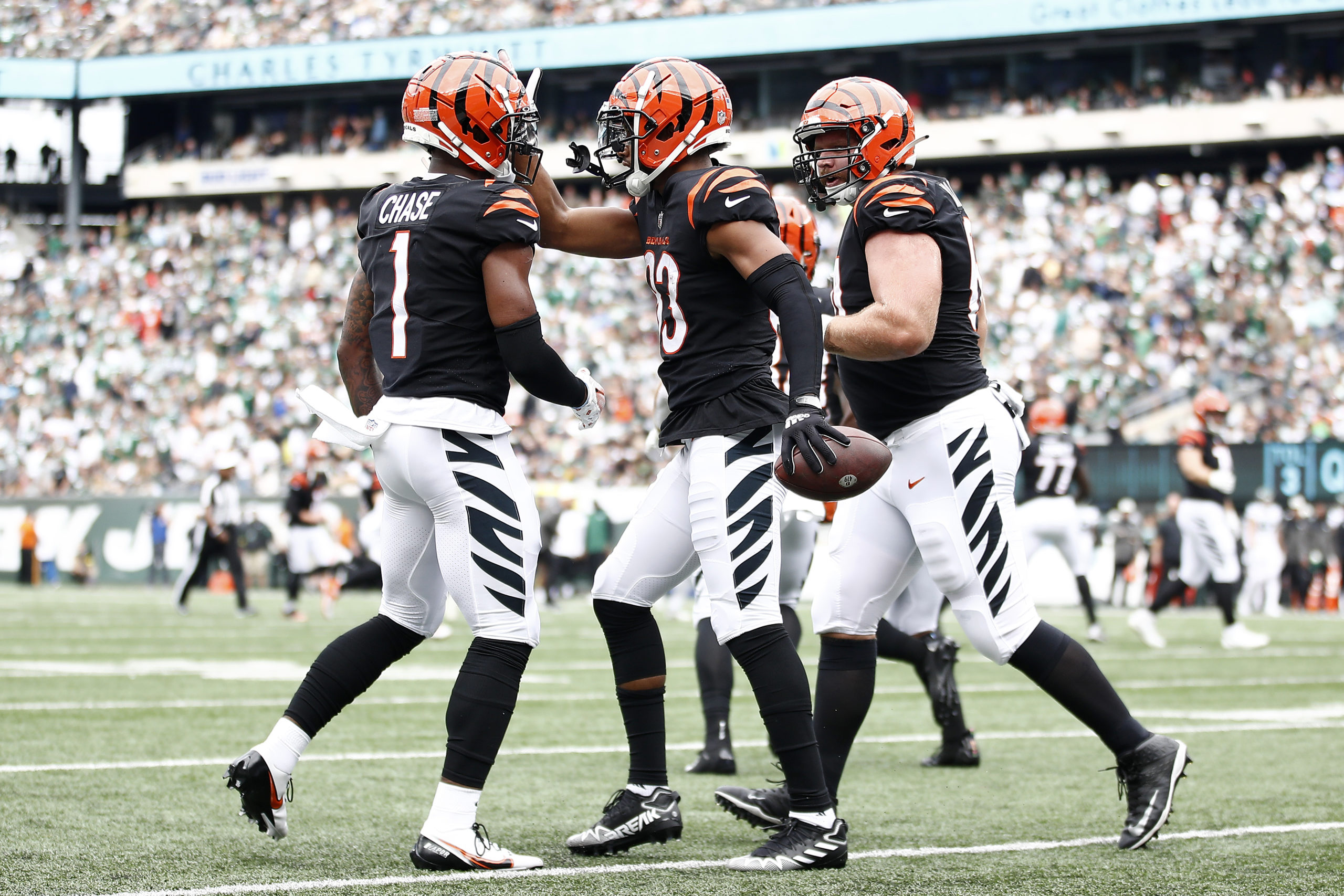 EAST RUTHERFORD, NEW JERSEY - SEPTEMBER 25: Tyler Boyd #83 of the Cincinnati Bengals celebrates with Ja'Marr Chase #1 (L) and Ted Karras #64 (R) after a catch for a touchdown against the New York Jets during the first half at MetLife Stadium on September 25, 2022 in East Rutherford, New Jersey. Sarah Stier/Getty Images