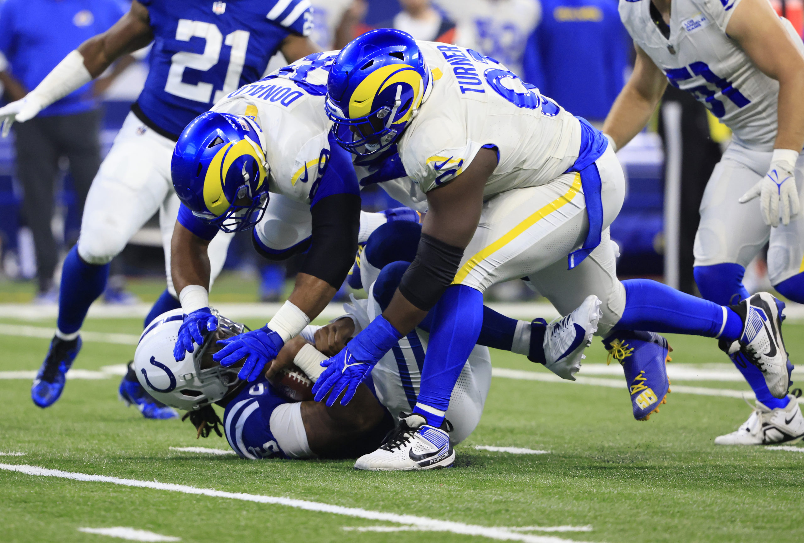 INDIANAPOLIS, INDIANA - OCTOBER 01: Anthony Richardson #5 of the Indianapolis Colts is sacked by Aaron Donald #99 of the Los Angeles Rams and Kobie Turner #91 of the Los Angeles Rams during the first half at Lucas Oil Stadium on October 01, 2023 in Indianapolis, Indiana. Justin Casterline/Getty Images