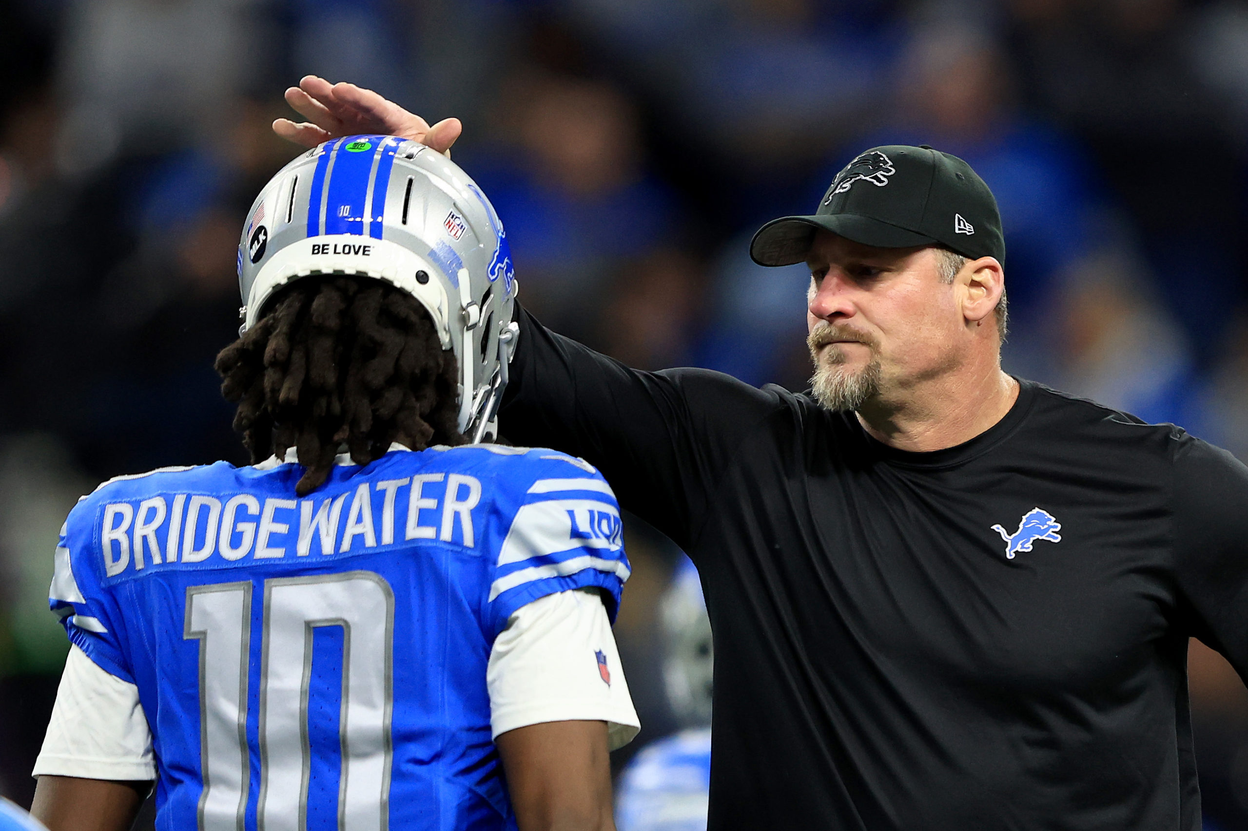 DETROIT, MICHIGAN - JANUARY 14: Head coach Dan Campbell of the Detroit Lions talks to Teddy Bridgewater #10 prior to a game against the Los Angeles Rams in the NFC Wild Card Playoffs at Ford Field on January 14, 2024 in Detroit, Michigan. Rey Del Rio/Getty Images