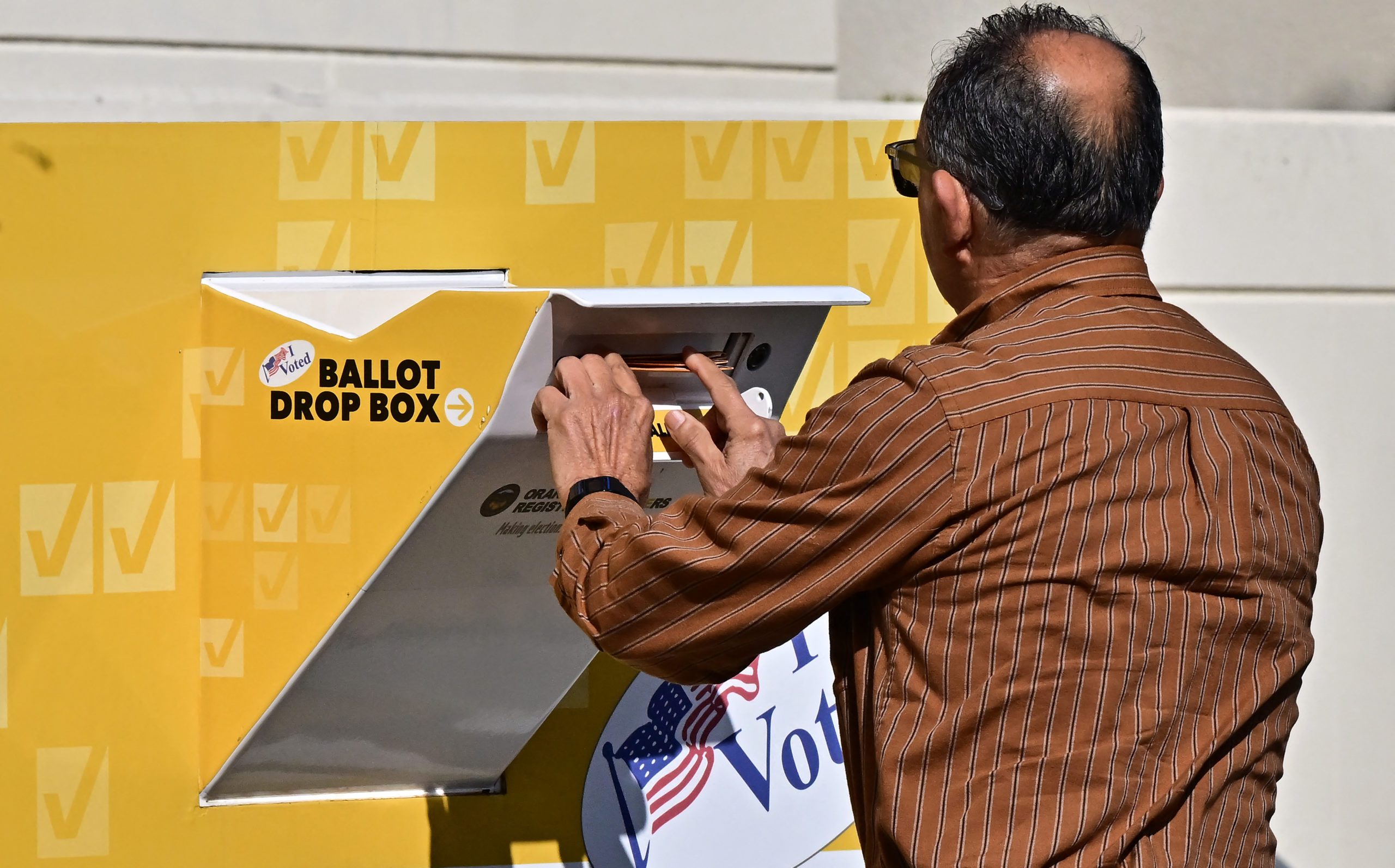 A man drops his ballot into a ballot box at the Orange County Registrar in Santa Ana, California on "Super Tuesday," March 5, 2024. (Photo by FREDERIC J. BROWN/AFP via Getty Images)