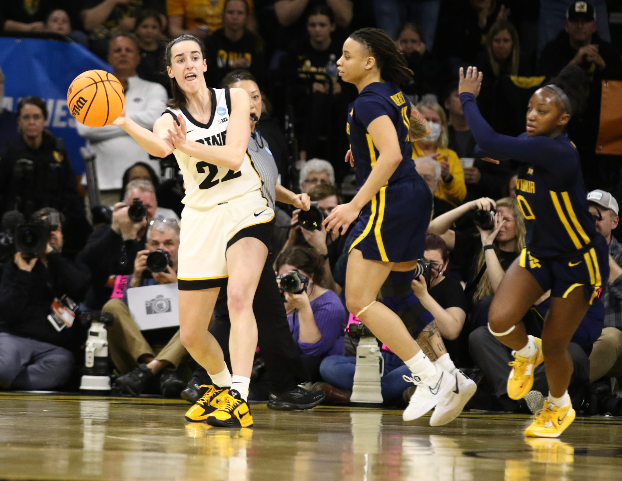 IOWA CITY, IOWA- MARCH 25: Guard Caitlin Clark #22 of the Iowa Hawkeyes passes the ball in the second half against guard J.J. Quinerly #11 of the West Virginia Mountaineers during their second round match-up in the 2024 NCAA Division 1 Women's Basketball Championship at Carver-Hawkeye Arena on March 25, 2024 in Iowa City, Iowa. Matthew Holst/Getty Images