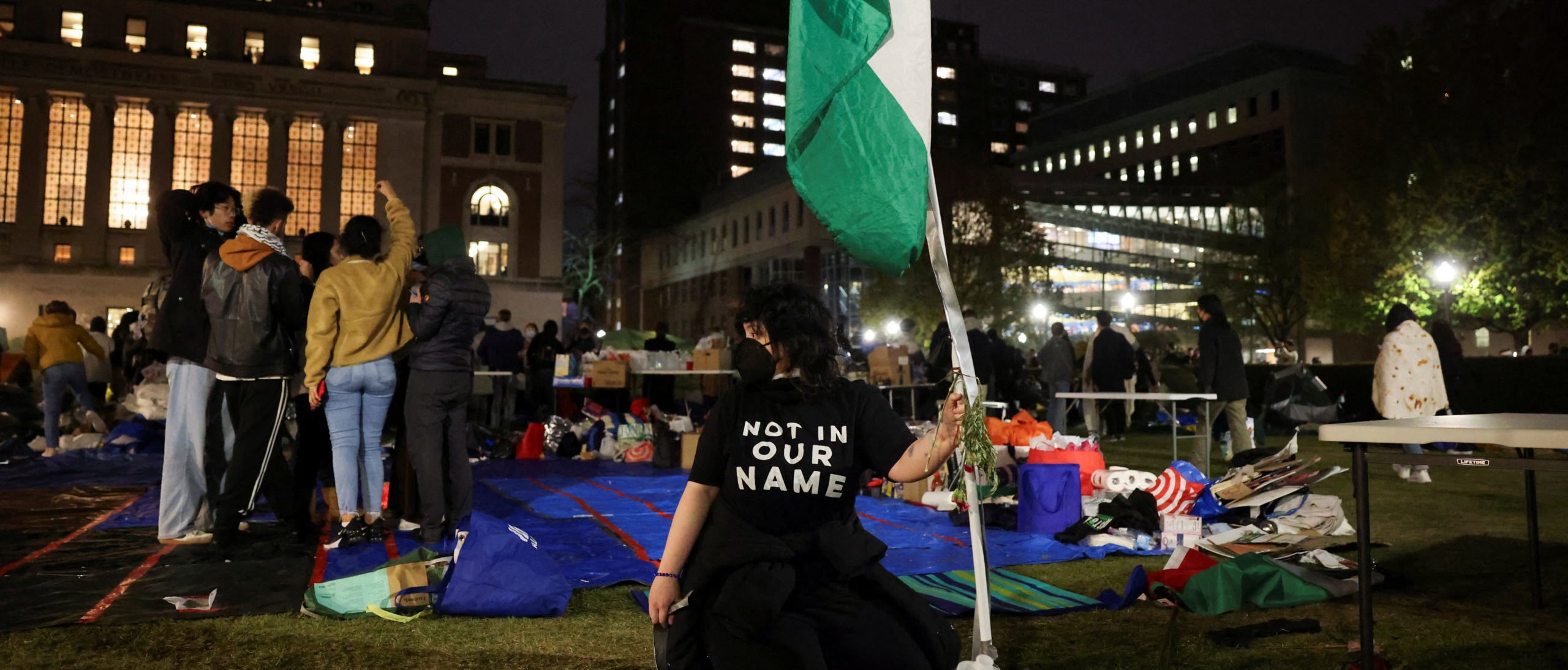 A student fixes a Palestinian flag as student protesters bring tents and supplies back into the protest encampment in support of Palestinians after a midnight deadline for protesters to leave the encampment on campus passed and it was reported to have been extended to 8 a.m., during the ongoing conflict between Israel and the Palestinian Islamist group Hamas, in New York City, U.S., April 23, 2024, REUTERS/Caitlin Ochs