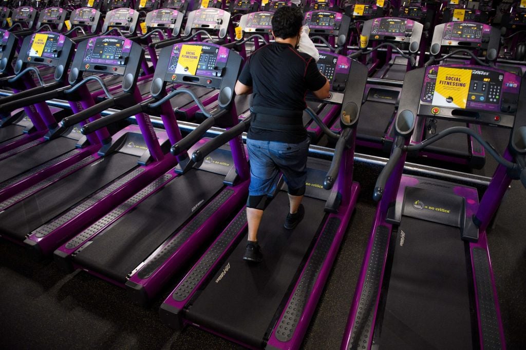 A customer wipes sweat from their face as they work out on a treadmill inside a Planet Fitness Inc. gym as the location reopens after being closed due to the Covid-19 pandemic, on March 16, 2021 in Inglewood, California. - Los Angeles County is allowing fitness centers and gyms to reopen for indoor workouts at ten percent capacity with customers wearing face masks under Covid-19 public health guidelines. (Photo by Patrick T. FALLON / AFP) (Photo by PATRICK T. FALLON/AFP via Getty Images)