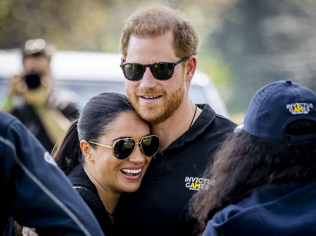 TOPSHOT - Duke and Duchess of Sussex, Prince Harry (R) and his wife, Meghan Markle embrace at The Invictus Games in The Hague on April 16, 2022. The Invictus Games is an international sporting event for servicemen and veterans who have been psychologically or physically injured in their military service. (Photo by Remko de Waal / ANP / AFP) / Netherlands OUT (Photo by REMKO DE WAAL/ANP/AFP via Getty Images)