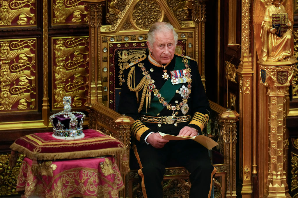 ONDON, ENGLAND - MAY 10: Prince Charles, Prince of Wales reads the Queen's speech next to her Imperial State Crown in the House of Lords Chamber, during the State Opening of Parliament in the House of Lords at the Palace of Westminster on May 10, 2022 in London, England. The State Opening of Parliament formally marks the beginning of the new session of Parliament. It includes Queen's Speech, prepared for her to read from the throne, by her government outlining its plans for new laws being brought forward in the coming parliamentary year. This year the speech will be read by the Prince of Wales as HM The Queen will miss the event due to ongoing mobility issues. (Photo by Alastair Grant - WPA Pool/Getty Images)