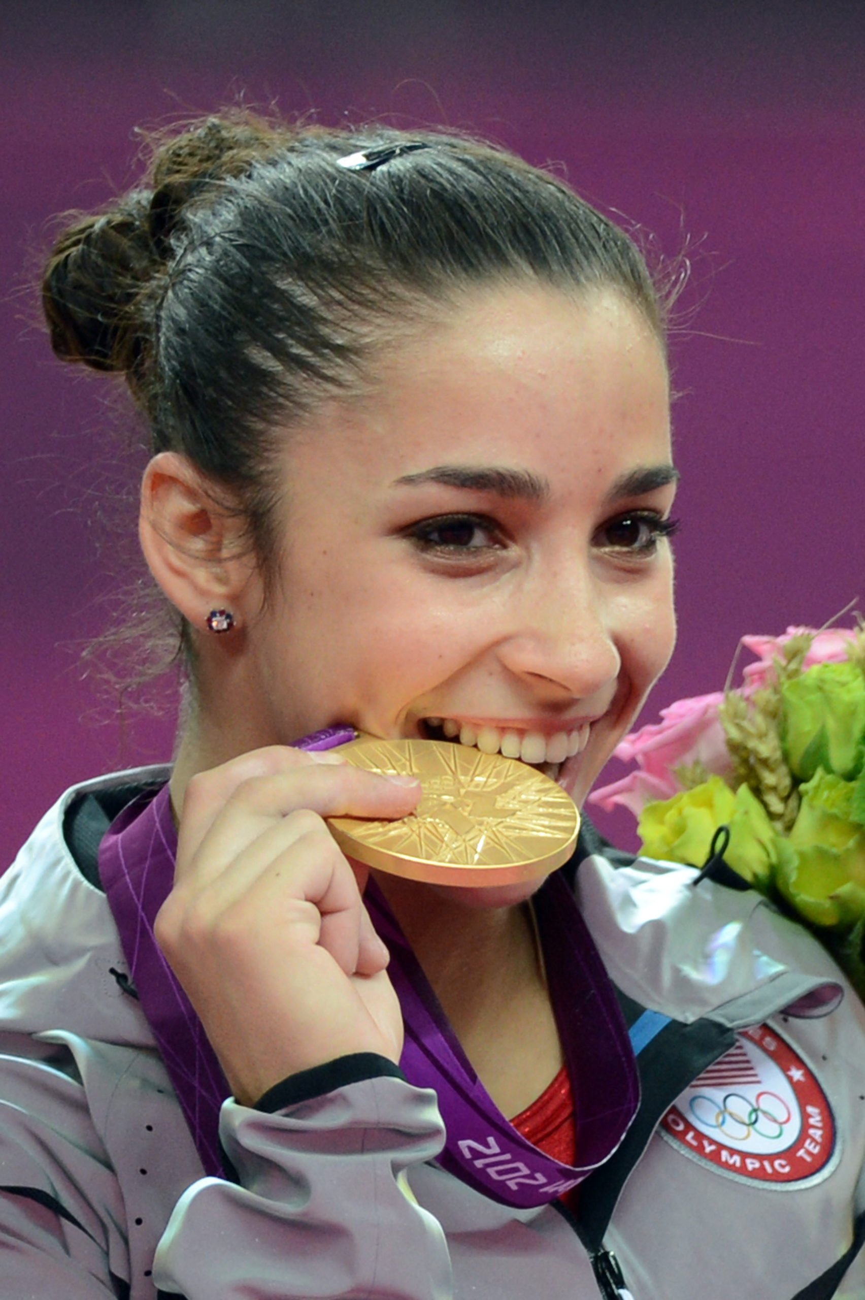 US gymnast Alexandra Raisman celebrates with the gold medal on the podium of the women's team final of the artistic gymnastics event of the London Olympic Games on July 31, 2012 at the 02 North Greenwich Arena in London. EMMANUEL DUNAND/AFP via Getty Images