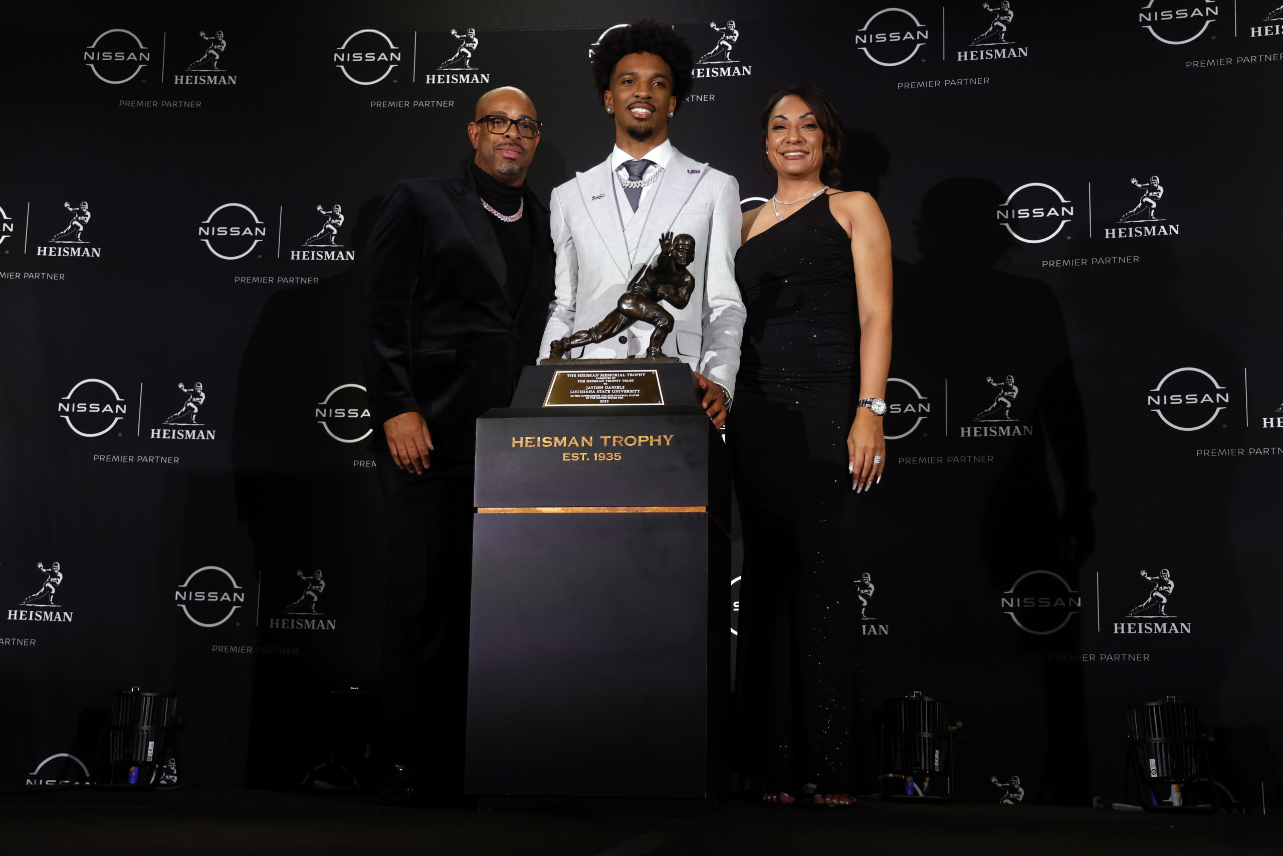 NEW YORK, NEW YORK - DECEMBER 09: Quarterback Jayden Daniels of the LSU Tigers and his parents pose with The Heisman Memorial Trophy at New York Marriott Marquis Hotel on December 09, 2023 in New York City. Sarah Stier/Getty Images