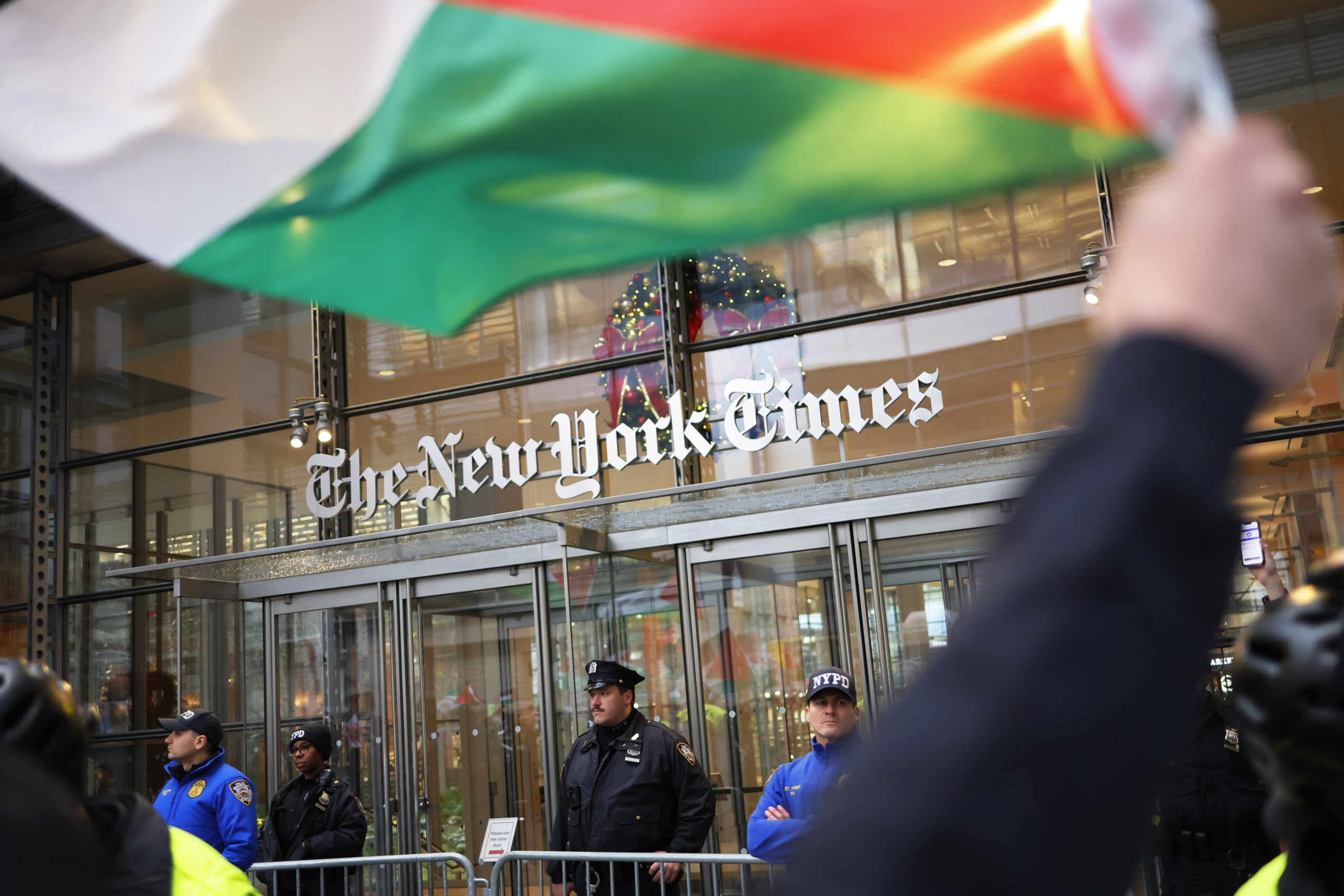 NYPD officers guard the entrance to the New York Times as Pro-Palestine activists march as they participate in a Global Strike for Gaza on December 18, 2023 in New York City, New York. Activists gathered at Grand Central Station before marching as they continued to demand a ceasefire in Gaza. The protest convened just as the UN Security Council canceled an upcoming vote calling for a cessation of hostilities in Gaza as they try to change the language of the resolution to meet the US objections to the wording of the draft resolution saying they cannot support a “cessation of hostilities," but would agree to a call for a “suspension of hostilities." (Photo by Michael M. Santiago/Getty Images)