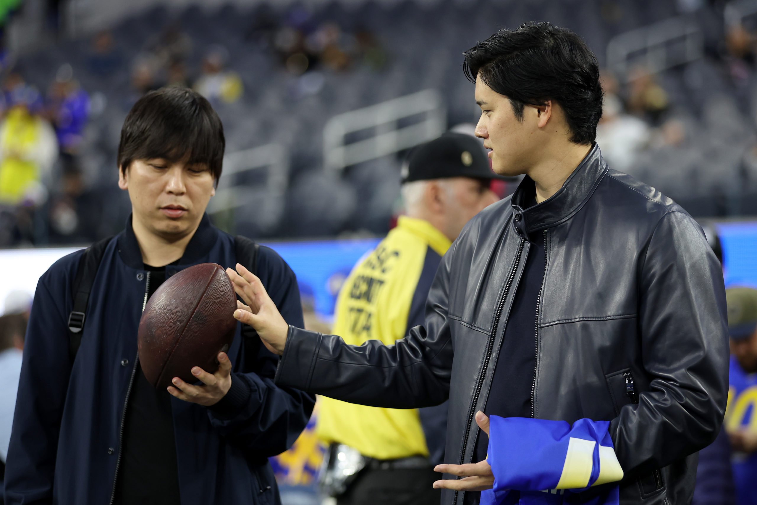 INGLEWOOD, CALIFORNIA - DECEMBER 21: Shohei Ohtani (R) of the Los Angeles Dodgers talks with his interpreter Ippei Mizuhara (L) prior to the game between the New Orleans Saints and the Los Angeles Rams at SoFi Stadium on December 21, 2023 in Inglewood, California. Sean M. Haffey/Getty Images