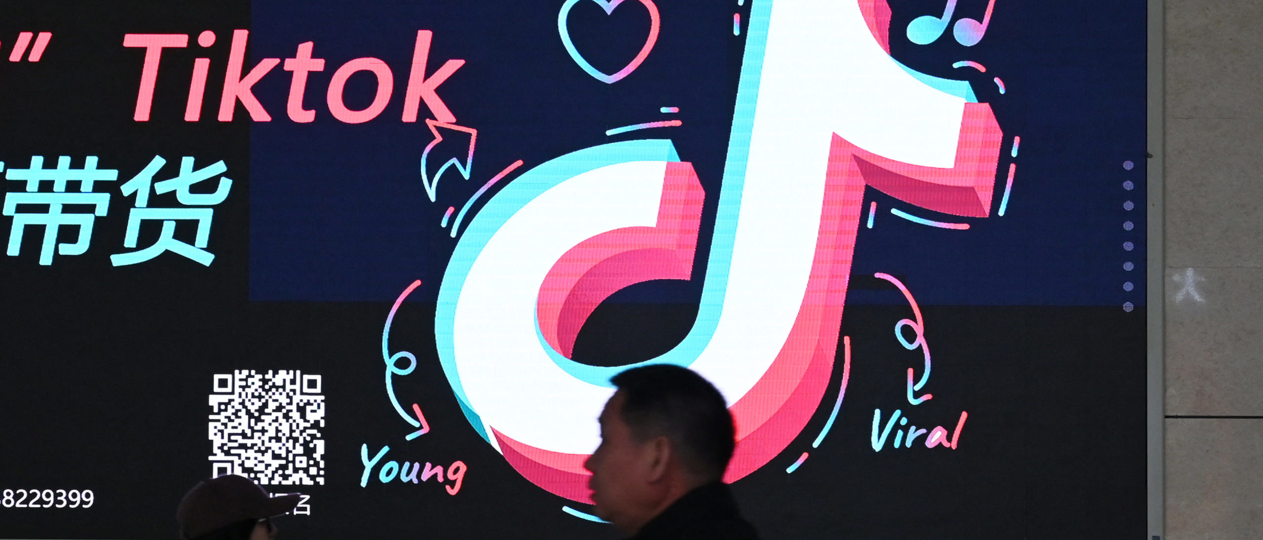People walk past an advertisement featuring the TikTok logo at a train station in Zhengzhou, in China's central Henan province on January 21, 2024. (Photo by Greg Baker/AFP via Getty Images)