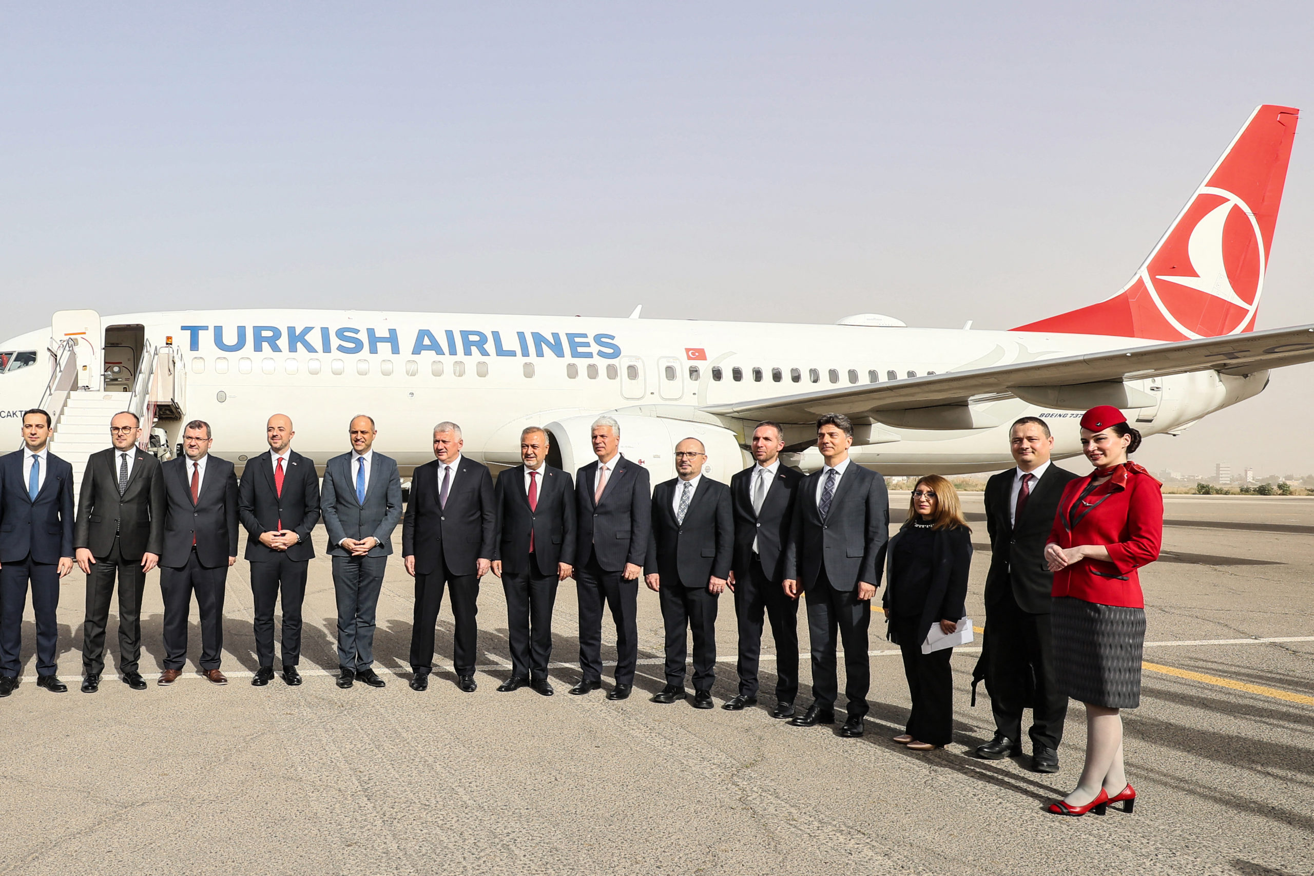 Libyan and Turkish officials pose in front of a Turkish Airlines air plane, following its first landing after a near 10-year hiatus, at the Mitiga International Airport in Tripoli on March 28, 2024. (Photo by MAHMUD TURKIA/AFP via Getty Images)
