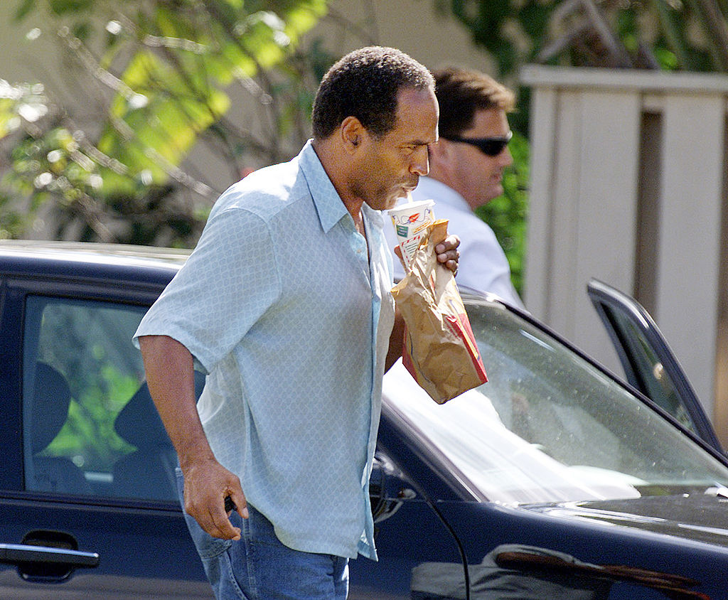 398144 02: Former NFL Star and Actor O.J. Simpson arrives December 4, 2001 at his home with Attorney Yale Galanter after FBI, Drug Enforcement Administration agents and Miami-Dade police detectives searched Simpson's Kendall, Florida home for more than six hours. The search is part of an investigation into an Ecstasy drug ring, the theft of equipment used to steal satellite television signals and money laundering. (Photo By Eliot J. Schechter/Getty Images)