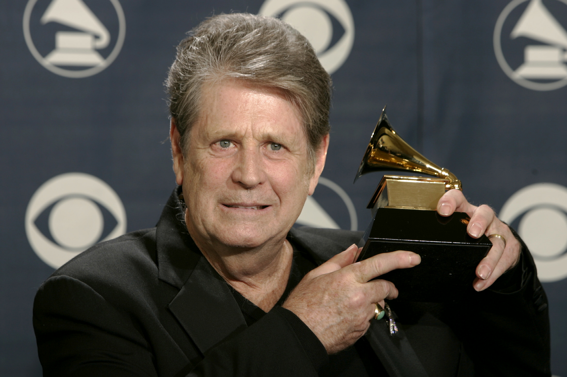Former Beach Boy Brian Wilson holds his award backstage at the 47th annual Grammy Awards at the Staples Center in Los Angeles February 13, 2005. Wilson won for Best Rock Instrumental Performance for "Mrs. O'Leary's Cow.