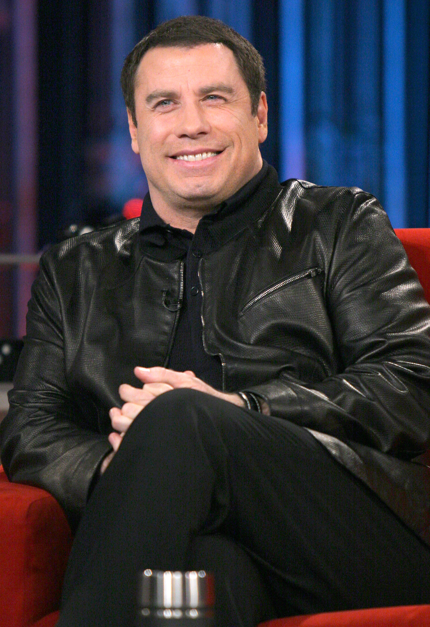 Actor John Travolta smiles during the tapping of 'Last Call with Carson Daly' in New York, February 23, 2005. Travolta is promoting his new comedy film 'Be Cool' which opens March 4 in the United States. REUTERS/Albert Ferreira AF