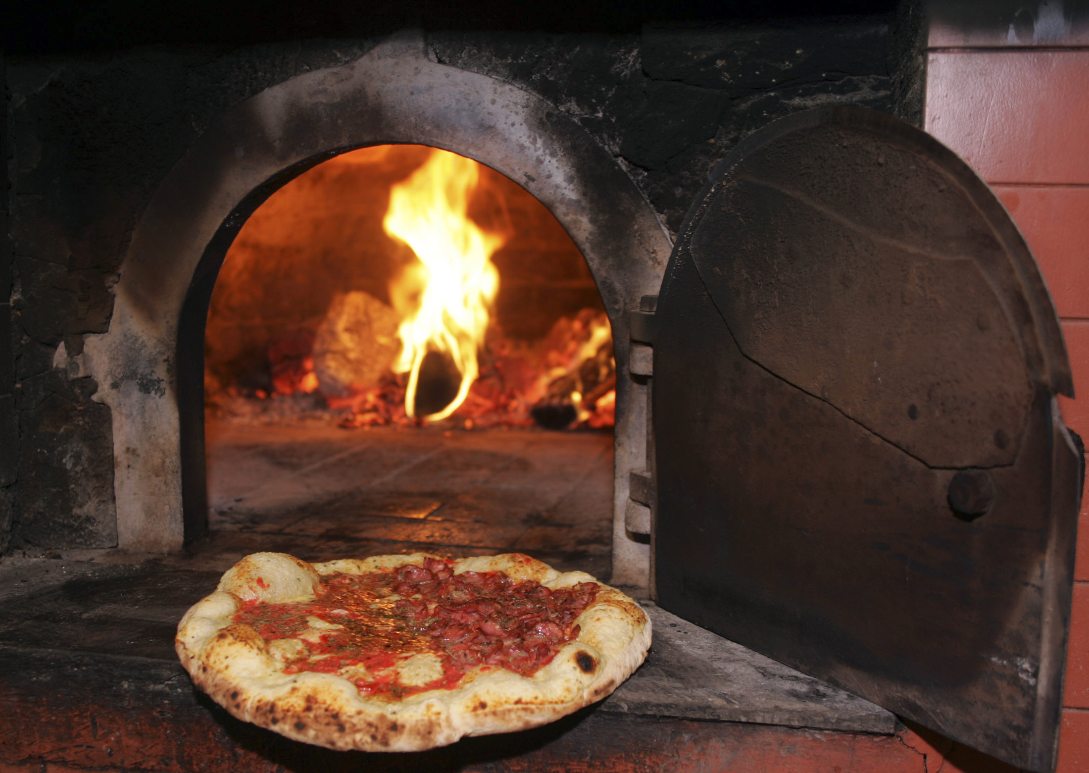 A Casteloes pizza is cooked in a wood-burning oven at Casteloes pizzeria in Sao Paulo, September 29, 2007. Sao Paulo is home to more than 6,000 pizza parlors that, in all, churn out close to a million pies a day, according to the local association of pizzerias. By some estimates, only New Yorkers devour more pizzas annually than Paulistanos. REUTERS/Paulo Whitaker (BRAZIL)