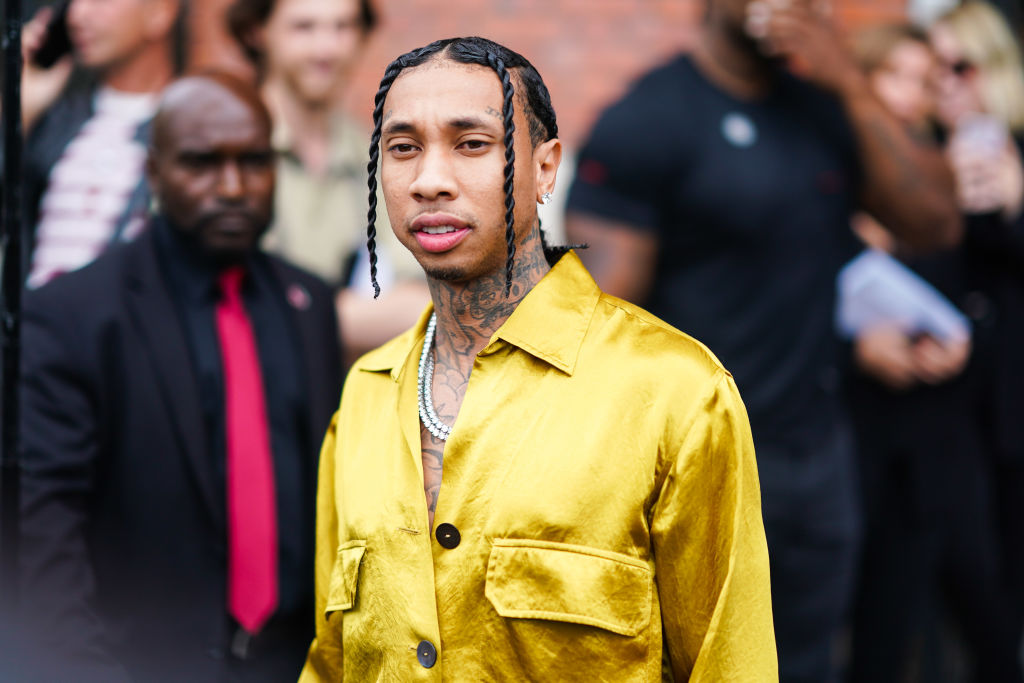 PARIS, FRANCE - SEPTEMBER 26: Tyga wears a yellow shiny shirt, tattoos, a necklace, outside Ann Demeulemeester, during Paris Fashion Week - Womenswear Spring Summer 2020 on September 26, 2019 in Paris, France. (Photo by Edward Berthelot/Getty Images)