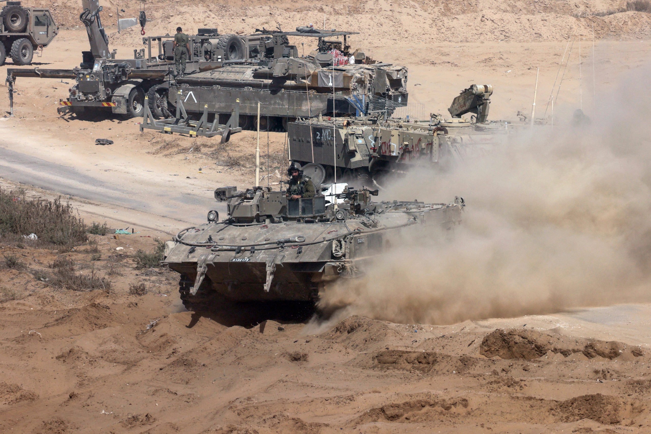 Israeli army armoured vehicles operate near the border with the Gaza Strip on May 30, 2024, amid the ongoing conflict between Israel and the Palestinian Hamas movement. (Photo by JACK GUEZ/AFP via Getty Images)
