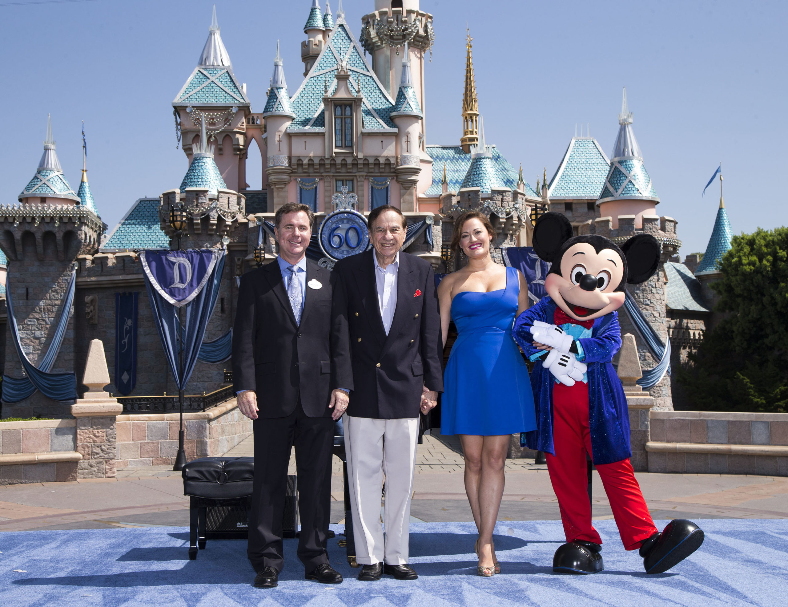 ANAHEIM, CA - JULY 17: In this handout photo provided by Disney parks, DAZZLING DAY - Academy Award-winning composer Richard Sherman and actress and singer Ashley Brown join President of the Disneyland Resort Michael Colglazier (L) and Mickey Mouse to celebrate the 60th anniversary of Disneyland park July 17, 2015 in Anaheim, California. Celebrating six decades of magic, the Disneyland Resort Diamond Celebration features three new nighttime spectaculars that immerse guests in the worlds of Disney stories like never before with "Paint the Night," the first all-LED parade at the resort; "Disneyland Forever," a reinvention of classic fireworks that adds projections to pyrotechnics to transform the park experience; and a moving new version of "World of Color" that celebrates Walt Disney's dream for Disneyland. (Photo by Paul Hiffmeyer/Disneyland Resort via Getty Images)