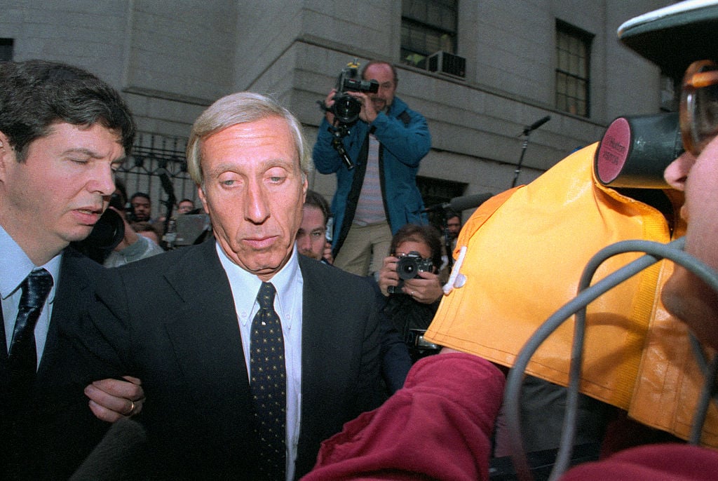 Members of the media surround corrupt financier Ivan Boesky and his attorney as they arrive at federal court in New York City, where he is to plead guilty to a criminal charge stemming from his insider trading. One of the richest men in the world, Boesky faces five years in prison.