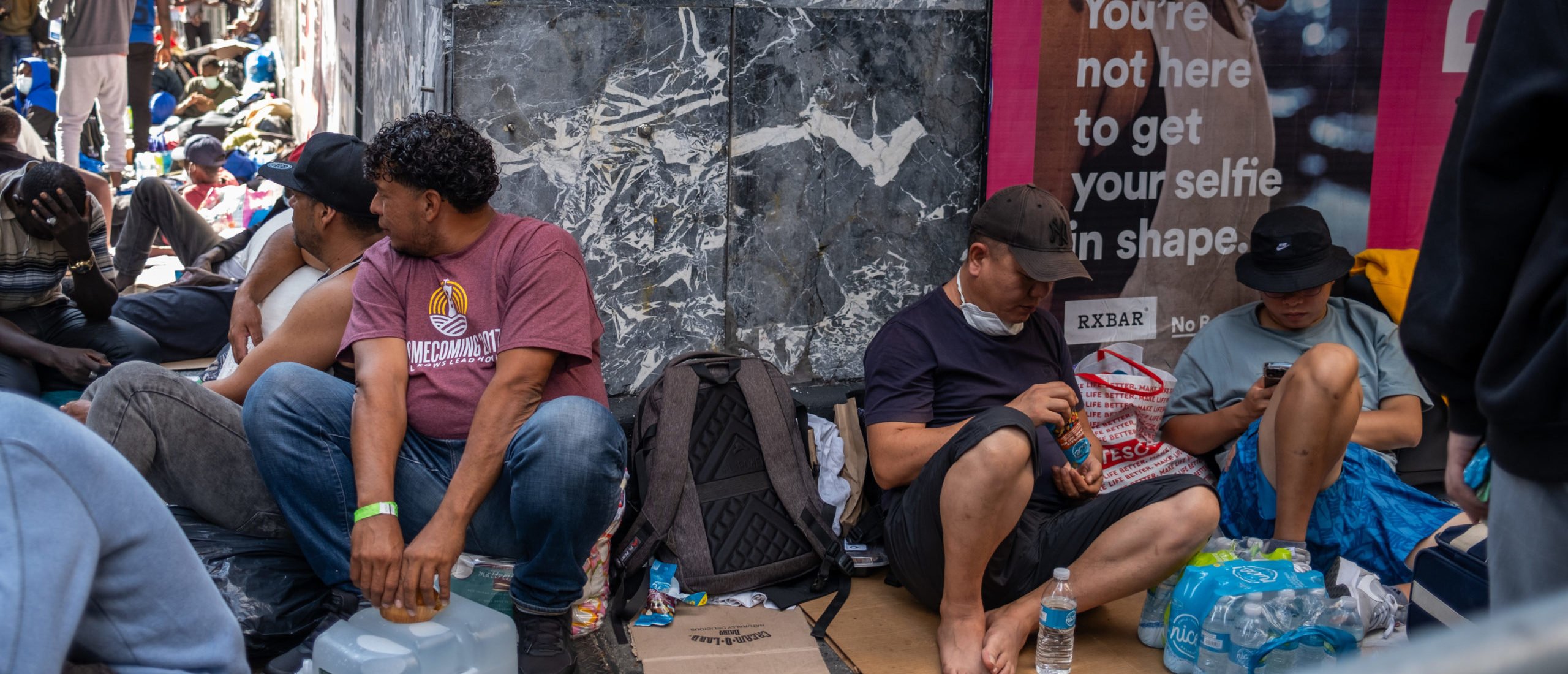 Migrants gather outside of the Roosevelt Hotel where dozens of recently arrived migrants have been camping out as they try to secure temporary housing on August 02, 2023 in New York City. (Photo by Alexi Rosenfeld/Getty Images)