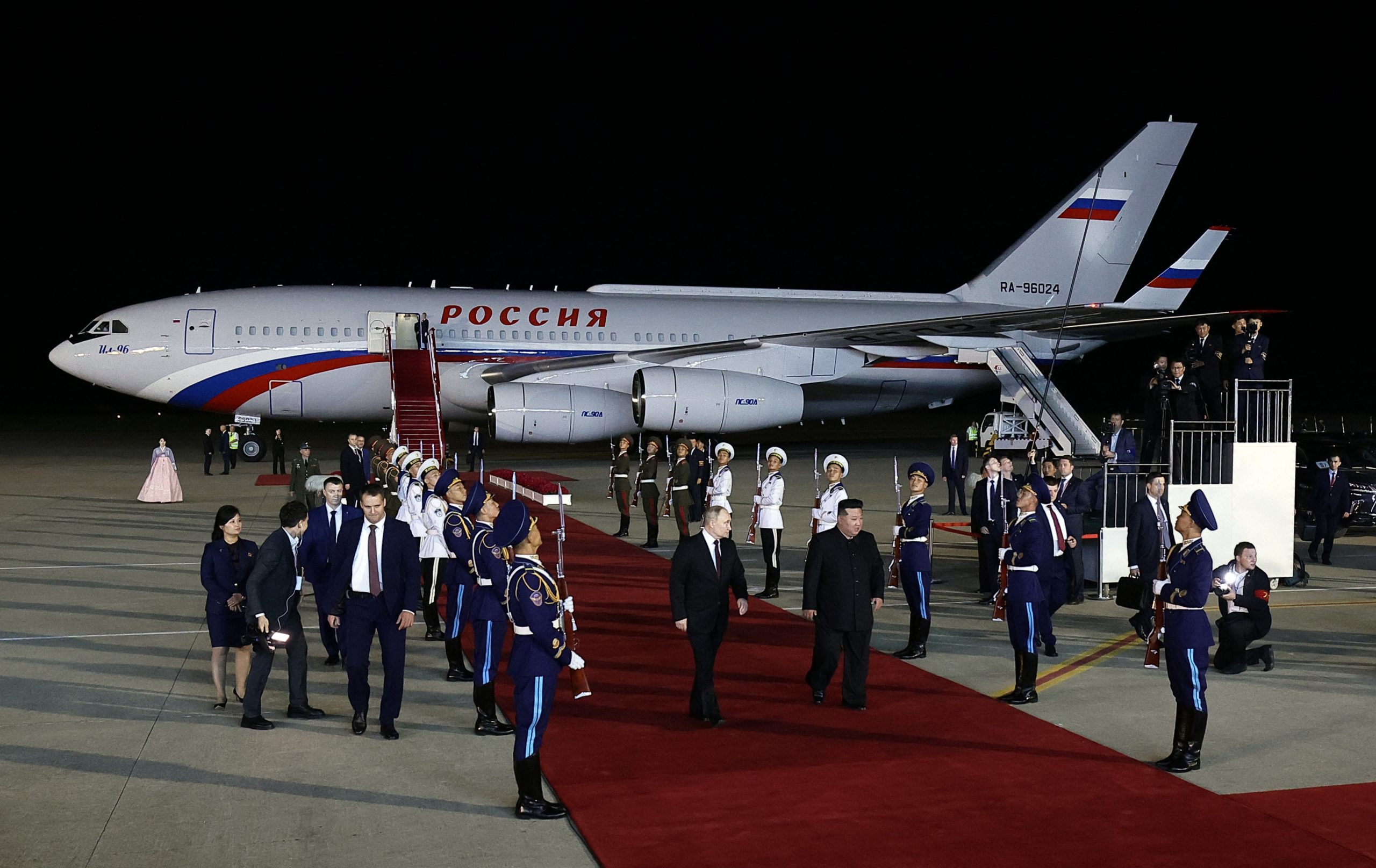 In this pool photograph distributed by the Russian state agency Sputnik, Russian President Vladimir Putin (C-L) and North Korea's leader Kim Jong Un (C-R) walk on the tarmac during a welcoming ceremony upon Putin's arrival at Pyongyang Airport, early on June 19, 2024. Russian President Vladimir Putin landed in North Korea early on June 19, the Kremlin said, kicking off a visit set to boost defence ties between the two nuclear-armed countries as Moscow pursues its war in Ukraine. VLADIMIR SMIRNOV/POOL/AFP via Getty Images