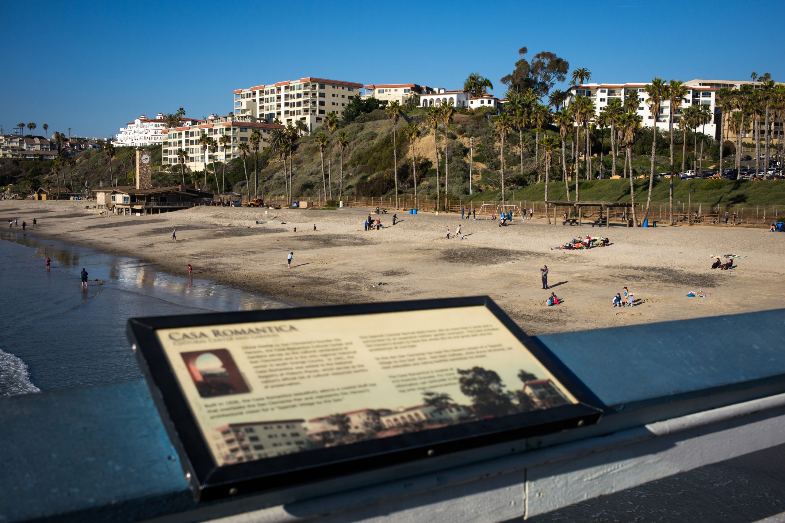 Tourists and local residents sit along the beach with a view of hillside condominiums January 2, 2015 in San Clemente, California. (Photo by Robert Nickelsberg/Getty Images)