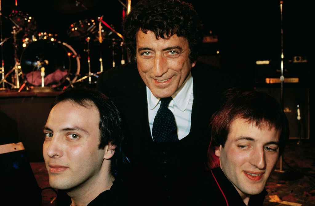 (Original Caption) Proud pop, singer Tony Bennett is all smiles as he poses with sons, Daegel (left), 23, and Danny, 24, after opening of "Neon," a rock 'n' roll group the sons belong to, at a club in Manhattan 1/17. Bennett flew in from Chicago to catch the opening. Danny, lead vocalist and guitarist for the group, has blue hair. Daegel, drummer, has dyed his hair red. "Neon" is a five-member group. The other artists have purple, green and yellow tresses. Getty Images