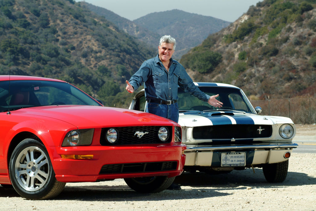 BURBANK, CA- JULY 24: Jay Leno road tests a 2005 Shelby Mustang GT for a British newspaper. He compared the car with a classic Shelby Mustang he owns, a 1965 Shelby Coupe GT. American Television personality Jay Leno who hosted the late night NBC "Tonight Show" collects cars. In 3 warehouses in a secure complex on the edge of Burbank airport he has over 100 cars, all insured, all in working order. The collection includes Bentleys, Bugatti's, McClaren, Cadillac, Hispano Suiza, Lamborghini, Morgans, Jaguars, there is also a collection of over 75 working motorcycles from the early 1920"s to a modern day Jet Bike July 24, 2004 Burbank, California (Photo Paul Harris/Getty Images)