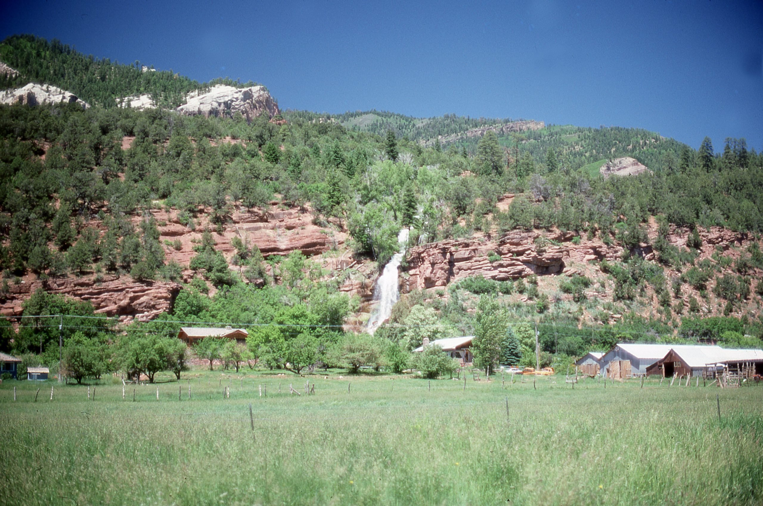 Ranch on a prairie field, with red clay cliffs in the background, a waterfall running through the cliffs, Arizona, 1970. (Photo by Smith Collection/Gado/Getty Images)