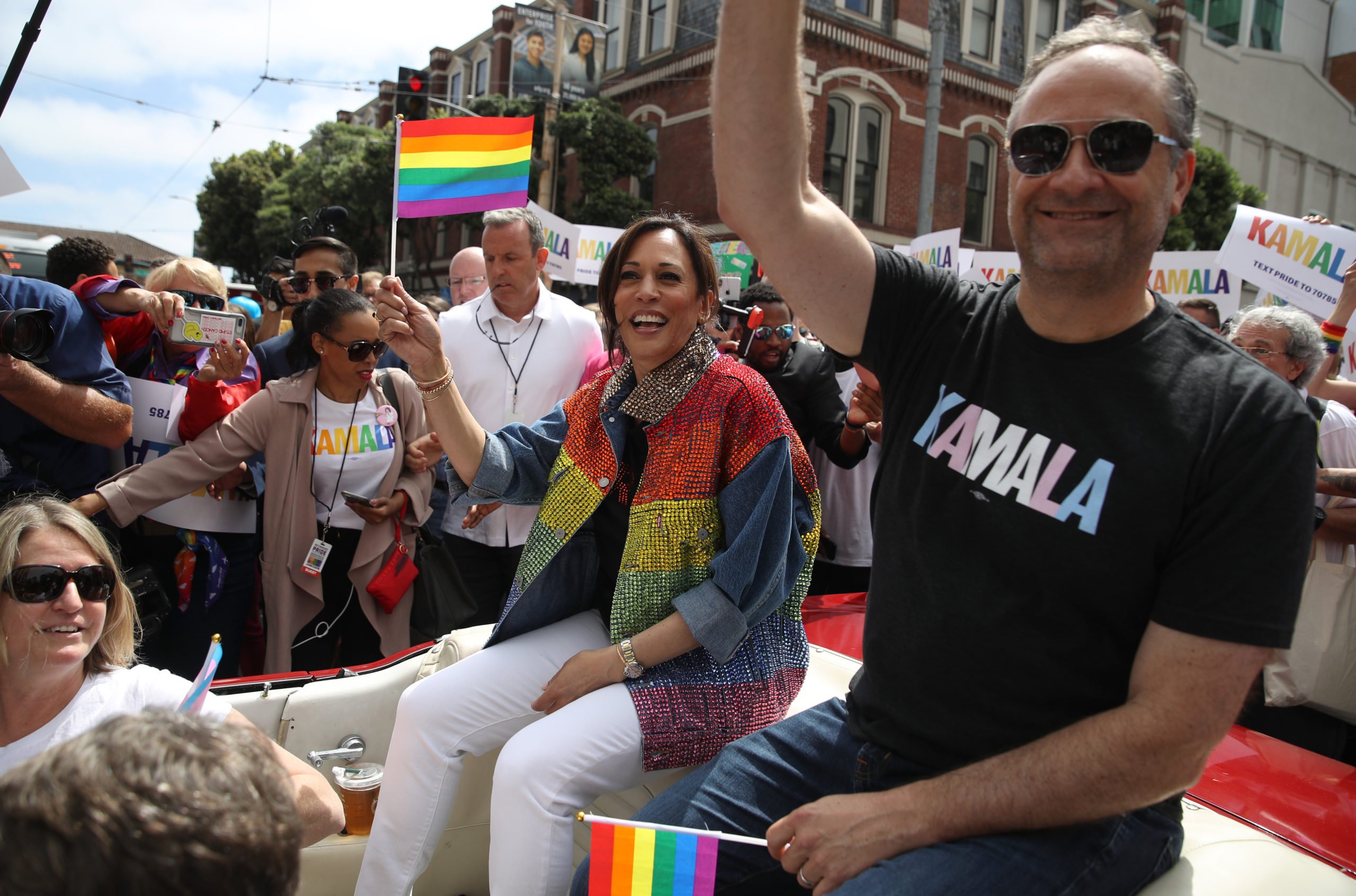 SAN FRANCISCO, CALIFORNIA - JUNE 30: Democratic presidential candidate U.S. Sen. Kamala Harris (L) (D-CA) and her husband Douglas Emhoff (R) wave to the crowd as they ride in a car during the SF Pride Parade on June 30, 2019 in San Francisco, California. Sen. Harris spent the weekend in the San Francisco Bay Area where she attended a fundraiser and the annual SF Pride Parade. (Photo by Justin Sullivan/Getty Images)