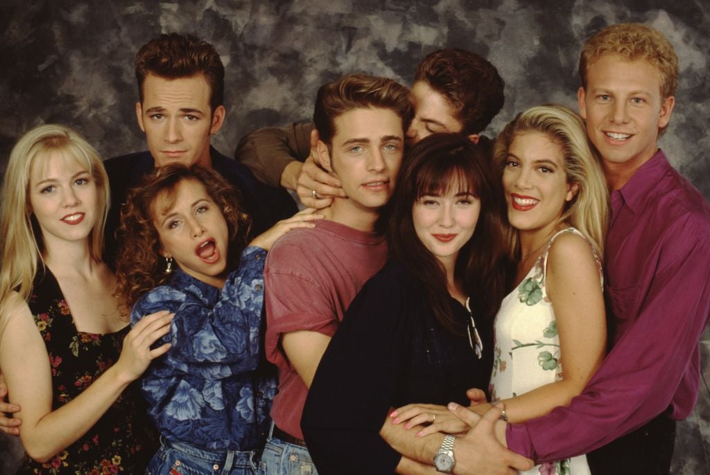 The Beverly Hills, 90210 cast poses for a portrait on set, September 1991 in Los Angeles, California. Left to right: Jennie Garth, Gabrielle Carteris, Luke Perry, Jason Priestley, Brian Austin Green, Shannen Doherty, Tori Spelling and Ian Ziering. (Photo by Mark Sennet/Getty Images)