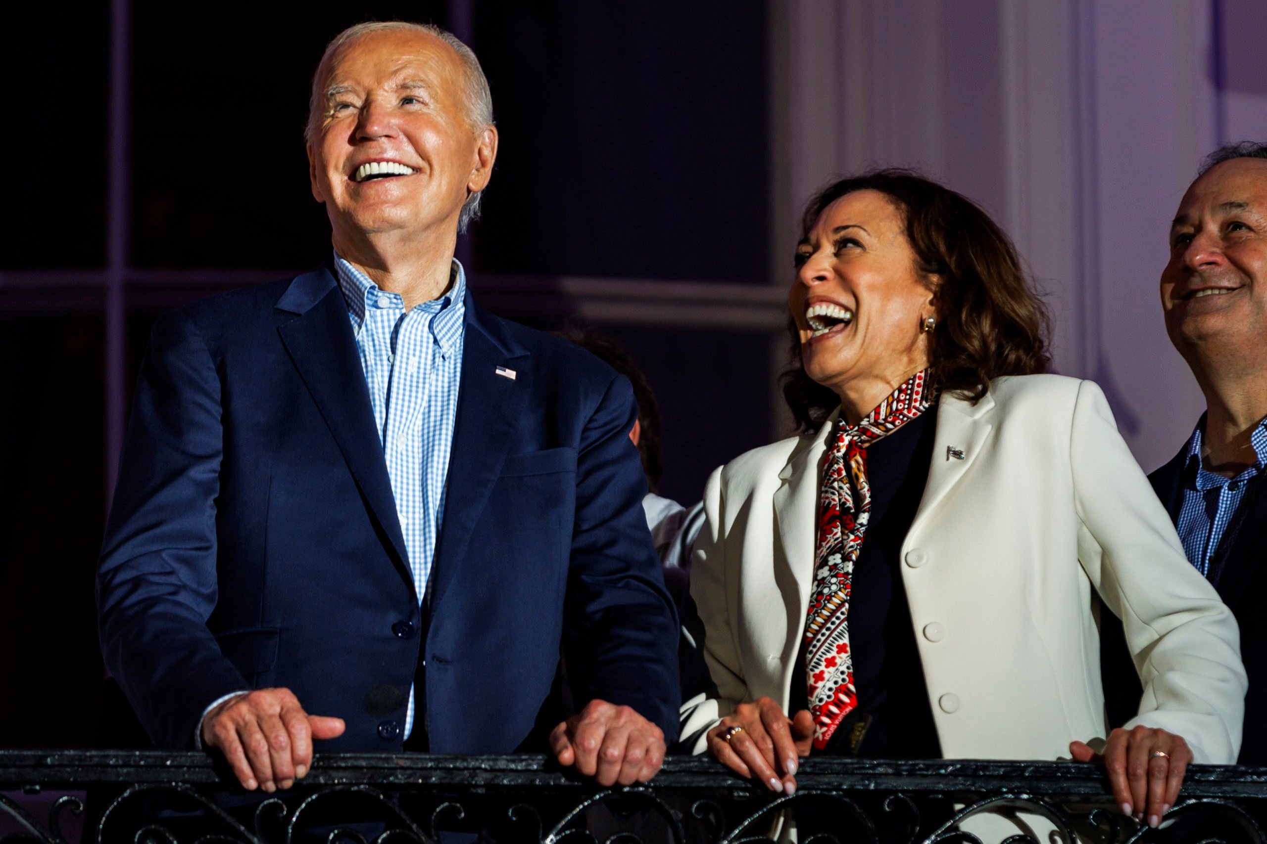 WASHINGTON, DC - JULY 04: President Joe Biden and Vice President Kamala Harris laugh as they view the fireworks on the National Mall from the White House balcony during a 4th of July event on the South Lawn of the White House on July 4, 2024 in Washington, DC. The President is hosting the Independence Day event for members of the military and their families. (Photo by Samuel Corum/Getty Images)